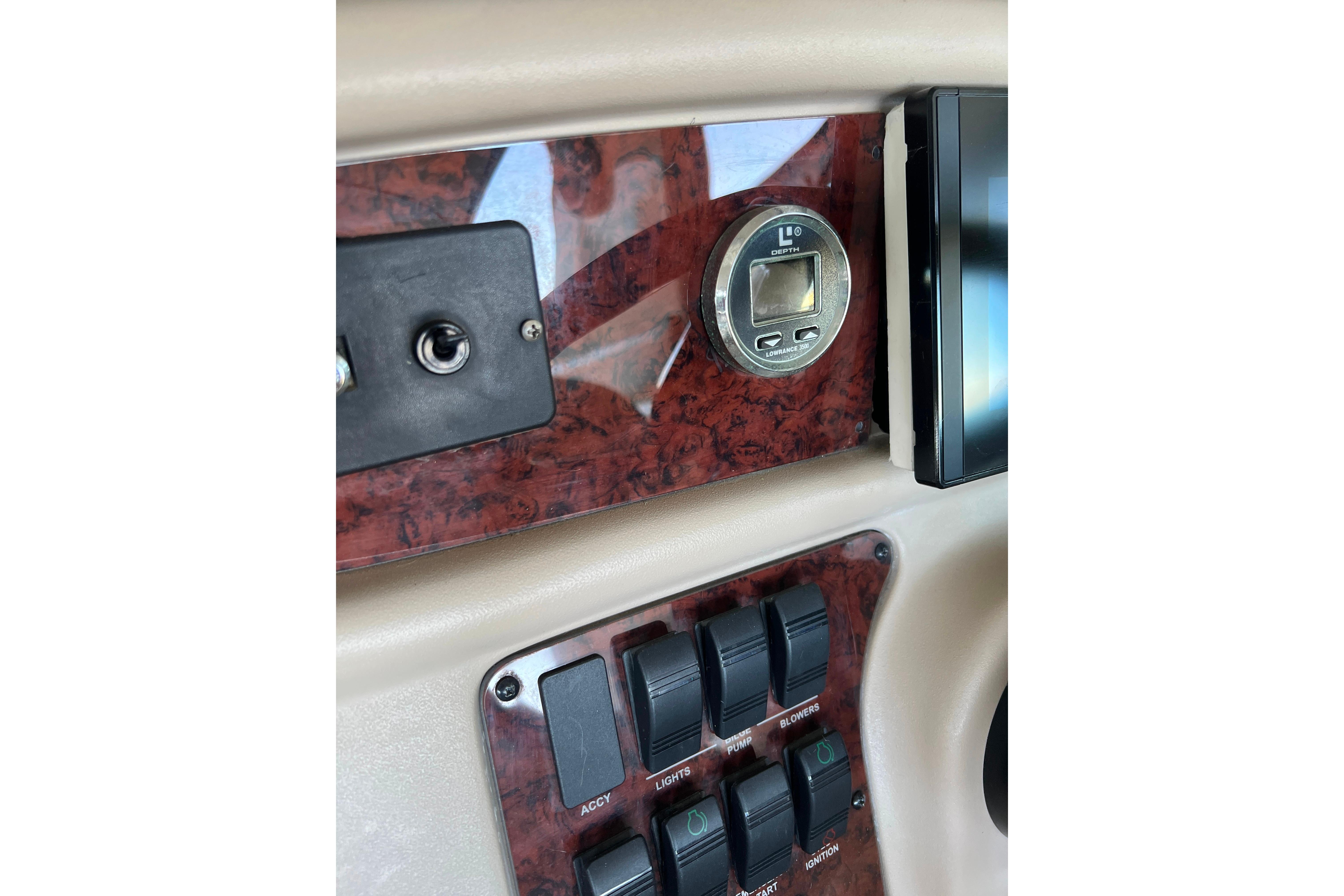 1999 Sea Ray 290 Sundancer dashboard with depth gauge and control switches.