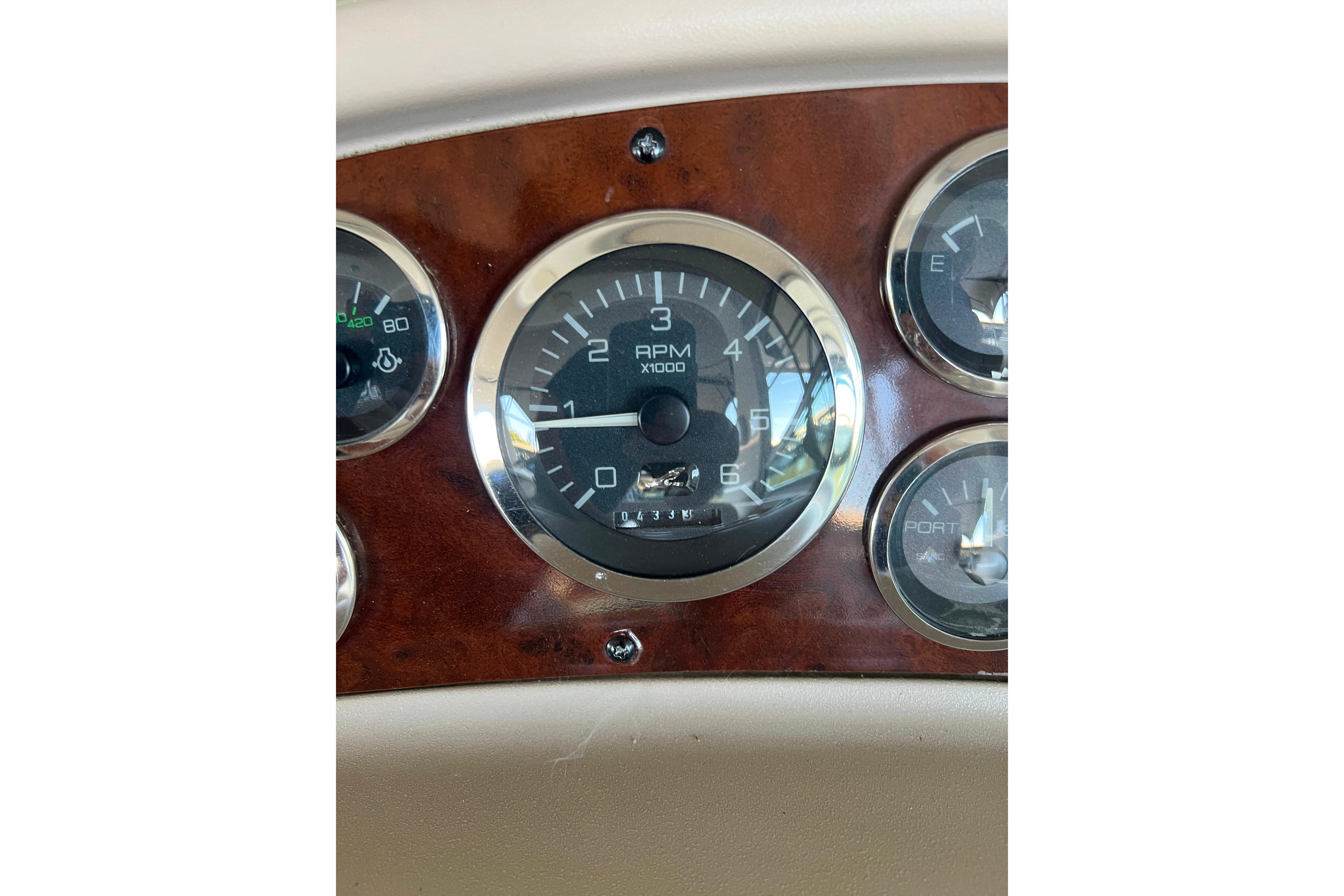 1999 Sea Ray 290 Sundancer dashboard with RPM gauge and wood paneling.