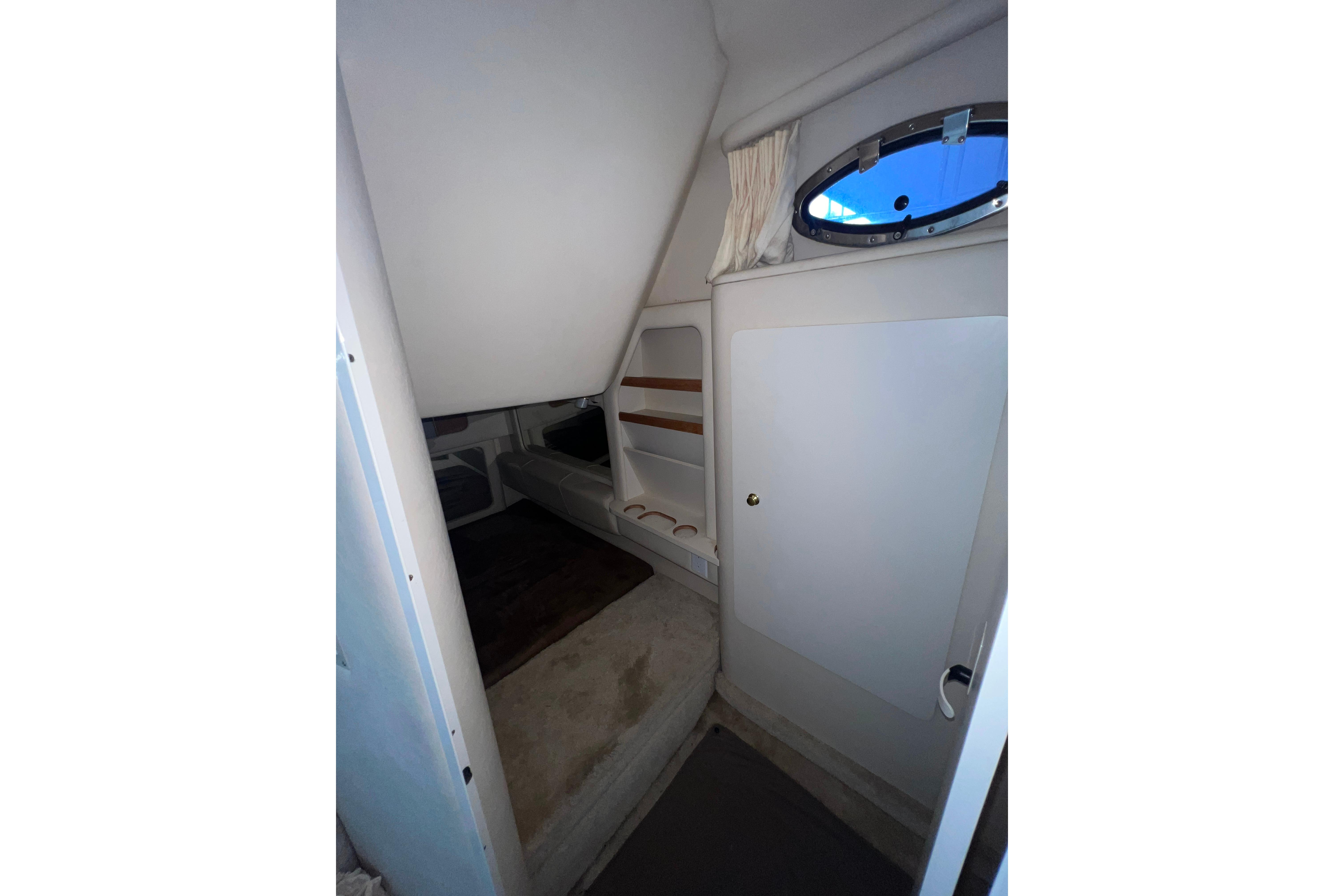 Interior cabin of 1999 Sea Ray 290 Sundancer with window and seating area.