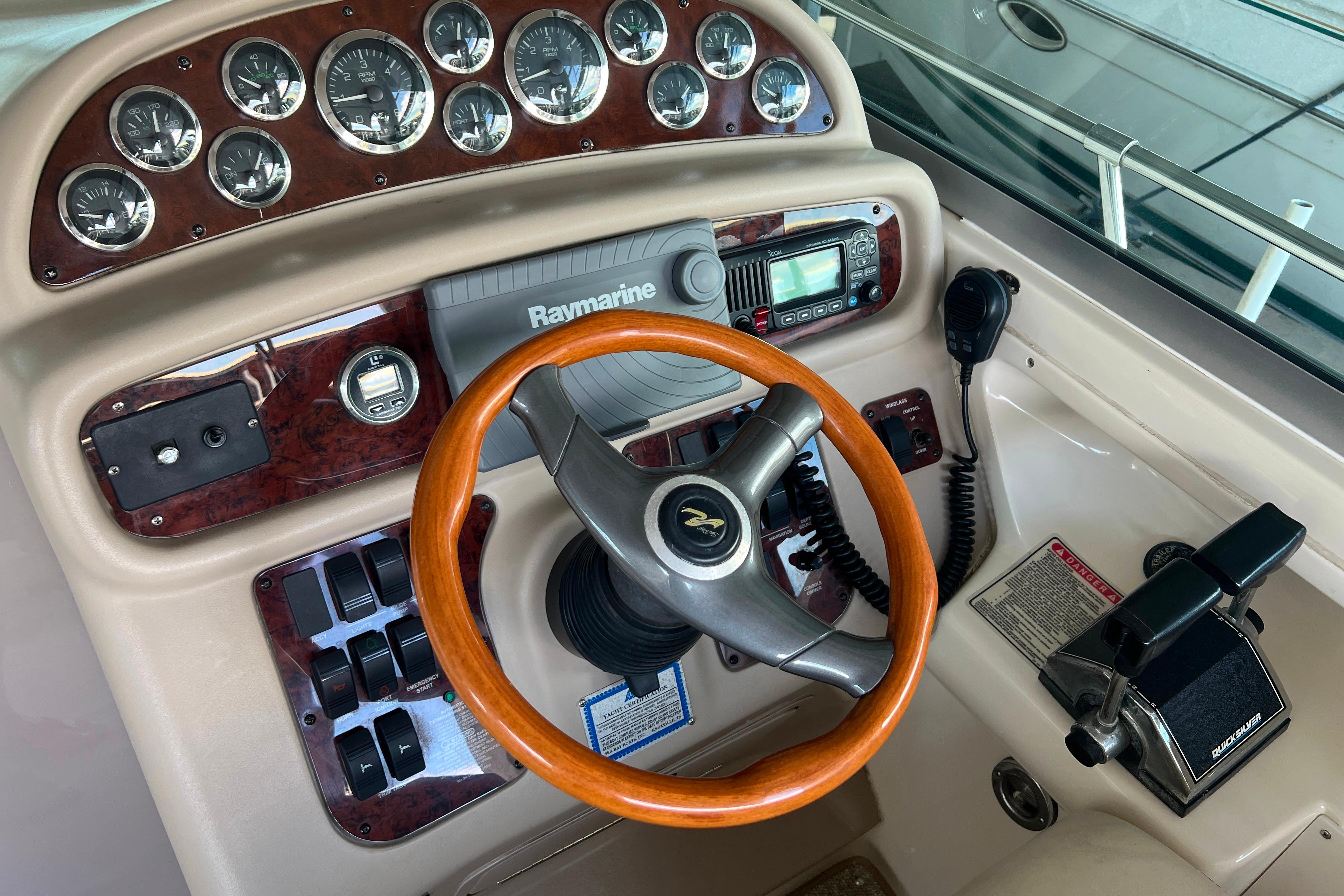 1999 Sea Ray 290 Sundancer helm with wood steering wheel and navigation instruments.