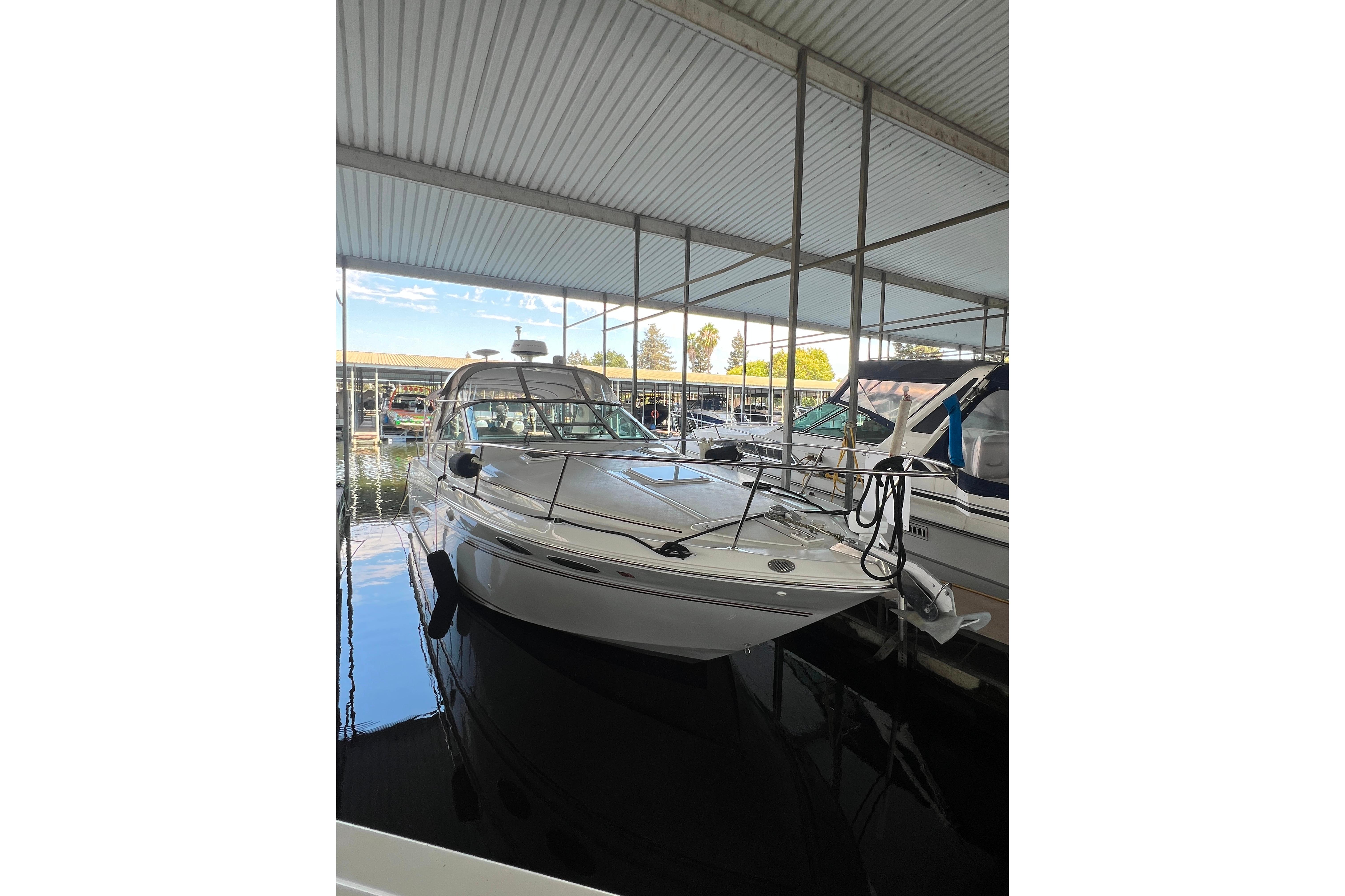 1999 Sea Ray 290 Sundancer docked in a covered marina.