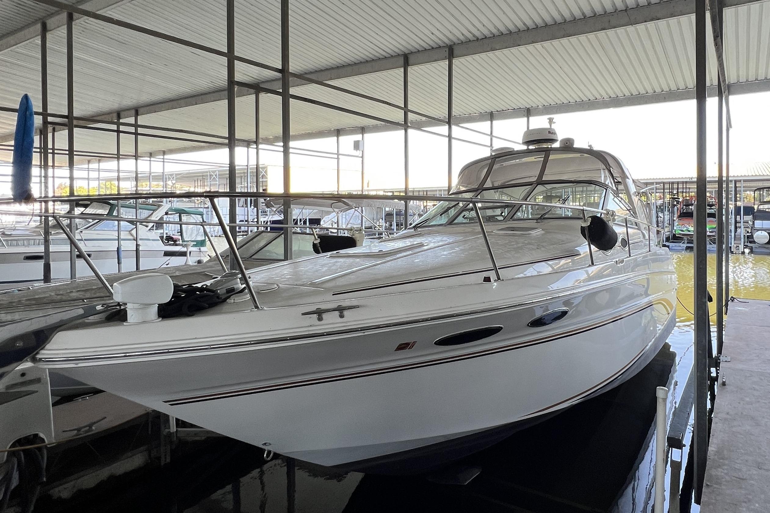 1999 Sea Ray 290 Sundancer docked in a covered marina, showcasing sleek design.