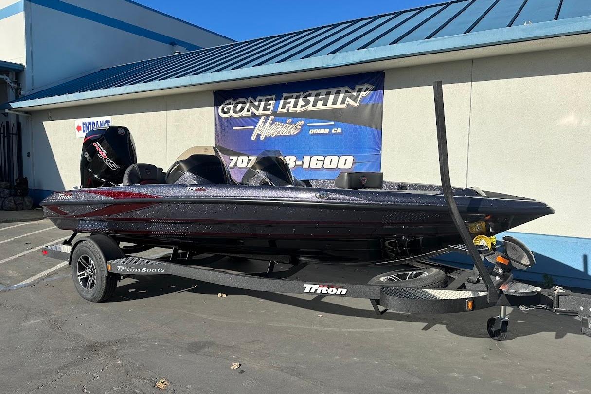2026 Triton 18 TrX boat on trailer outside a marine store.