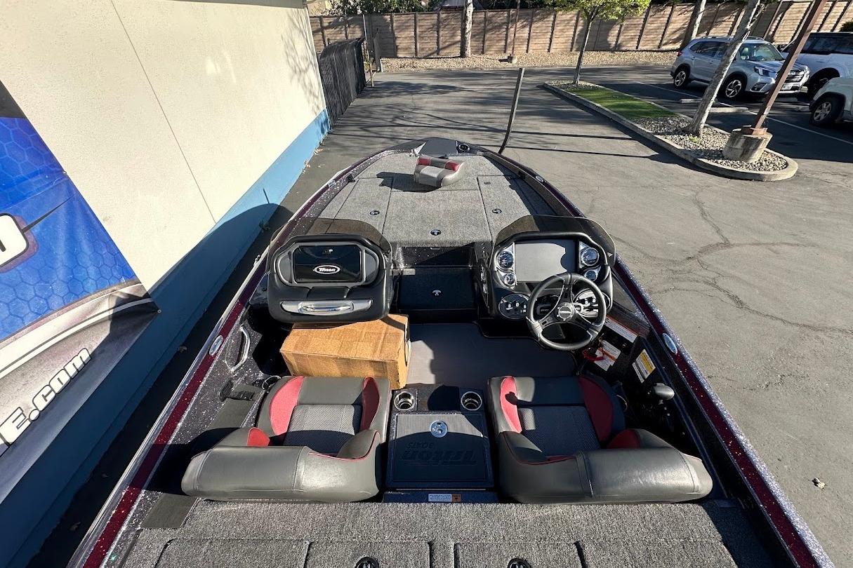 2026 Triton 18 TrX boat interior with steering wheel and seating, parked outdoors.