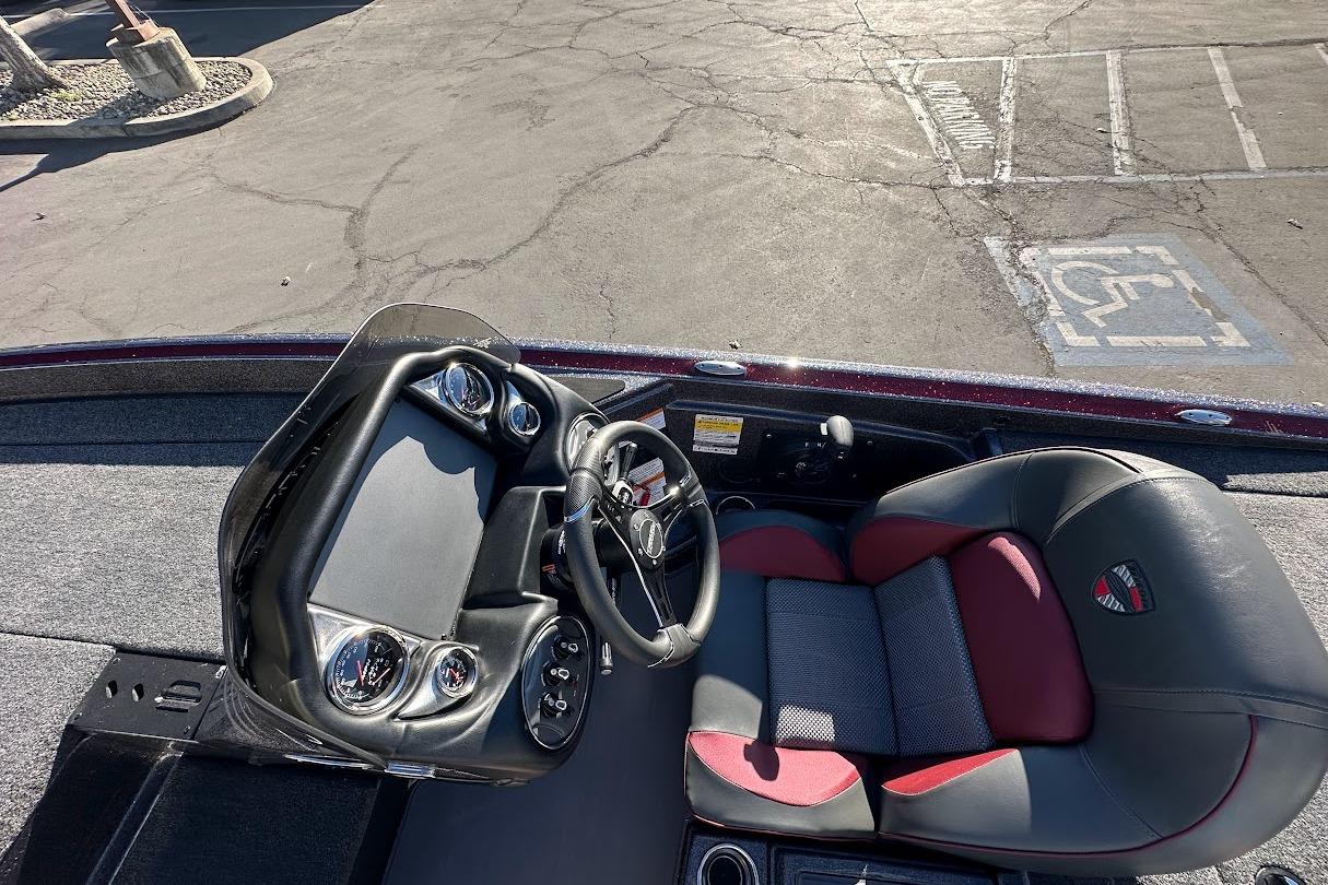 2026 Triton 18 TrX boat cockpit with steering wheel and cushioned seat.