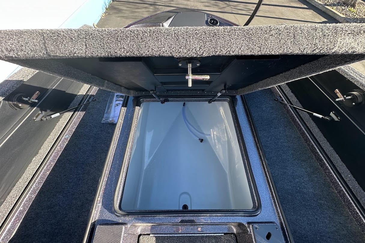 Open storage compartment of 2026 Triton 18 TrX boat, showcasing interior details.