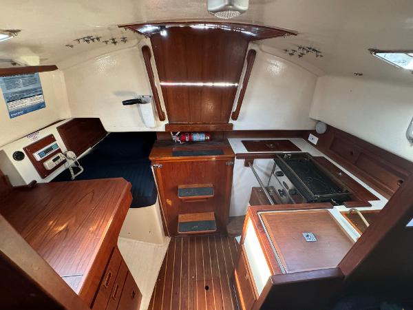 Interior of a 1990 Contessa 32 sailboat with wooden furnishings.