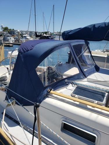 1990 Contessa 32 sailboat with blue cover in harbor.