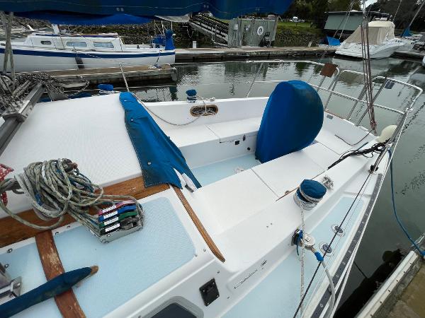 1984 Catalina 30 sailboat docked, featuring a clean deck and neatly arranged ropes.