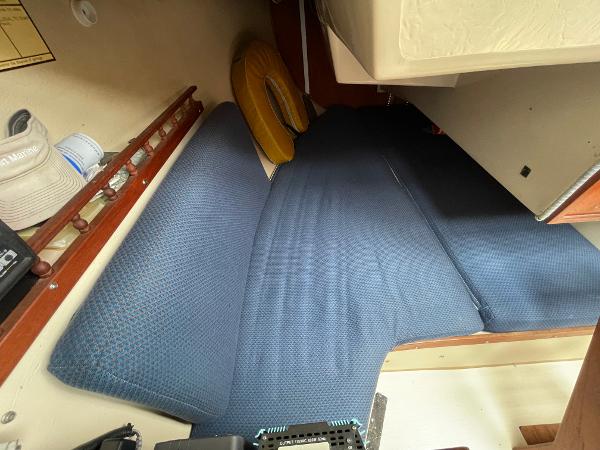 Interior cabin of a 1984 Catalina 30 sailboat with blue cushions.