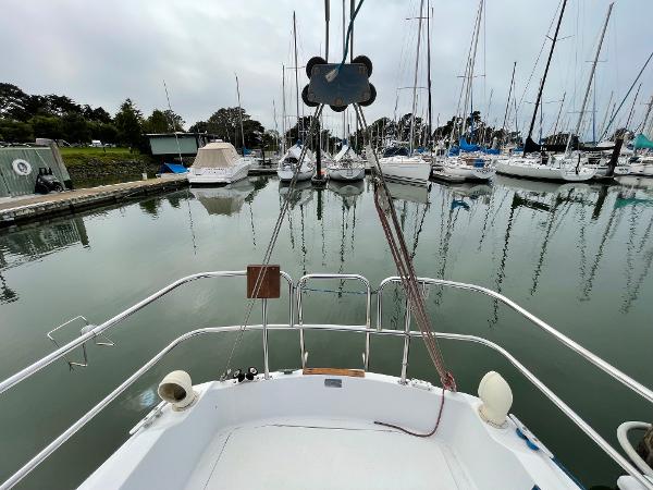 1984 Catalina 30 sailboat docked in a marina, surrounded by other boats.