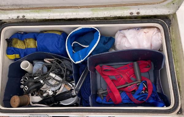 Storage compartment on a 1984 Catalina 30 sailboat with various boating equipment.
