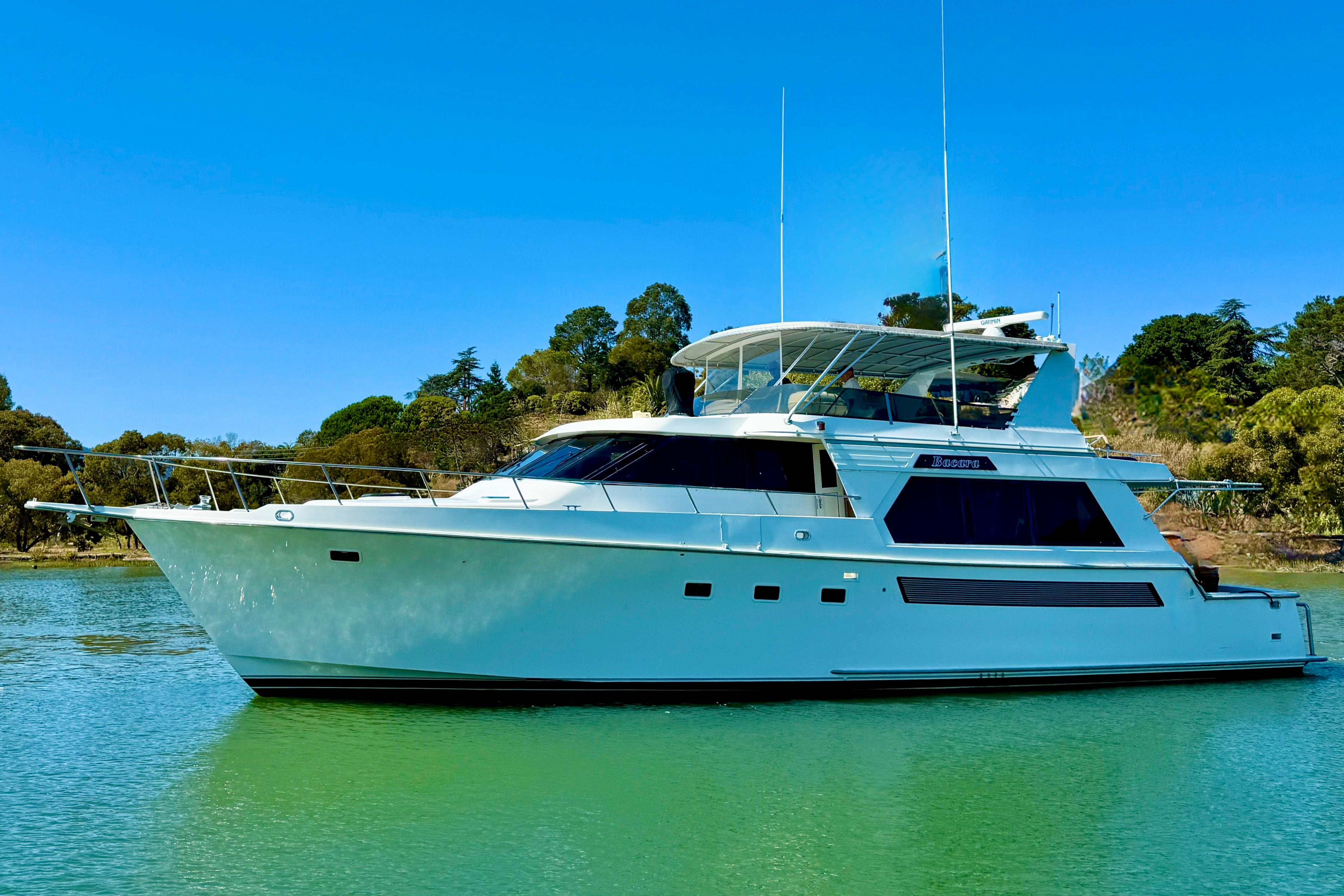 1993 Tollycraft 57 Pilothouse Motor Yacht on serene water, surrounded by lush greenery.
