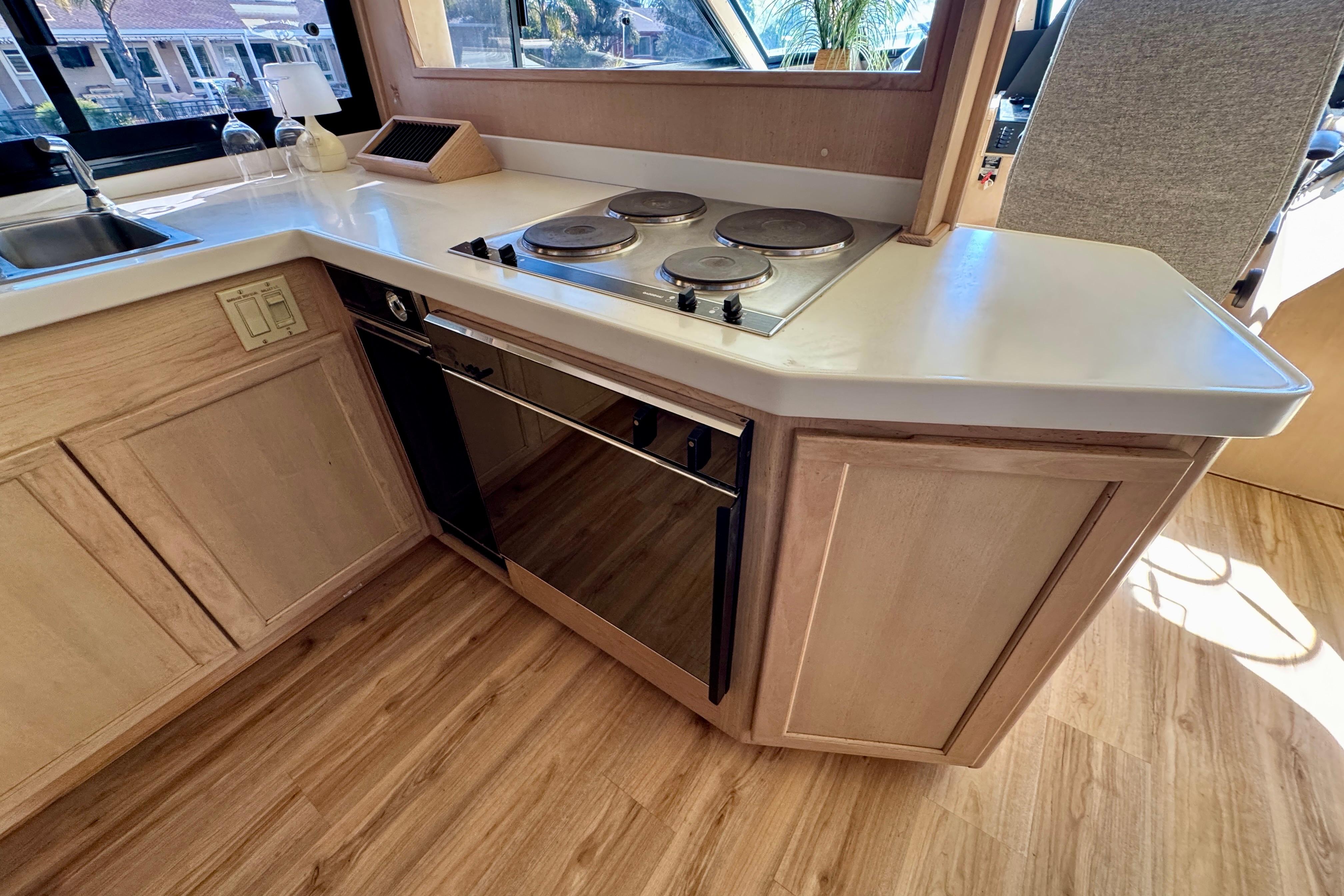 1993 Tollycraft 57 Pilothouse Motor Yacht kitchen with stove and wooden cabinetry.