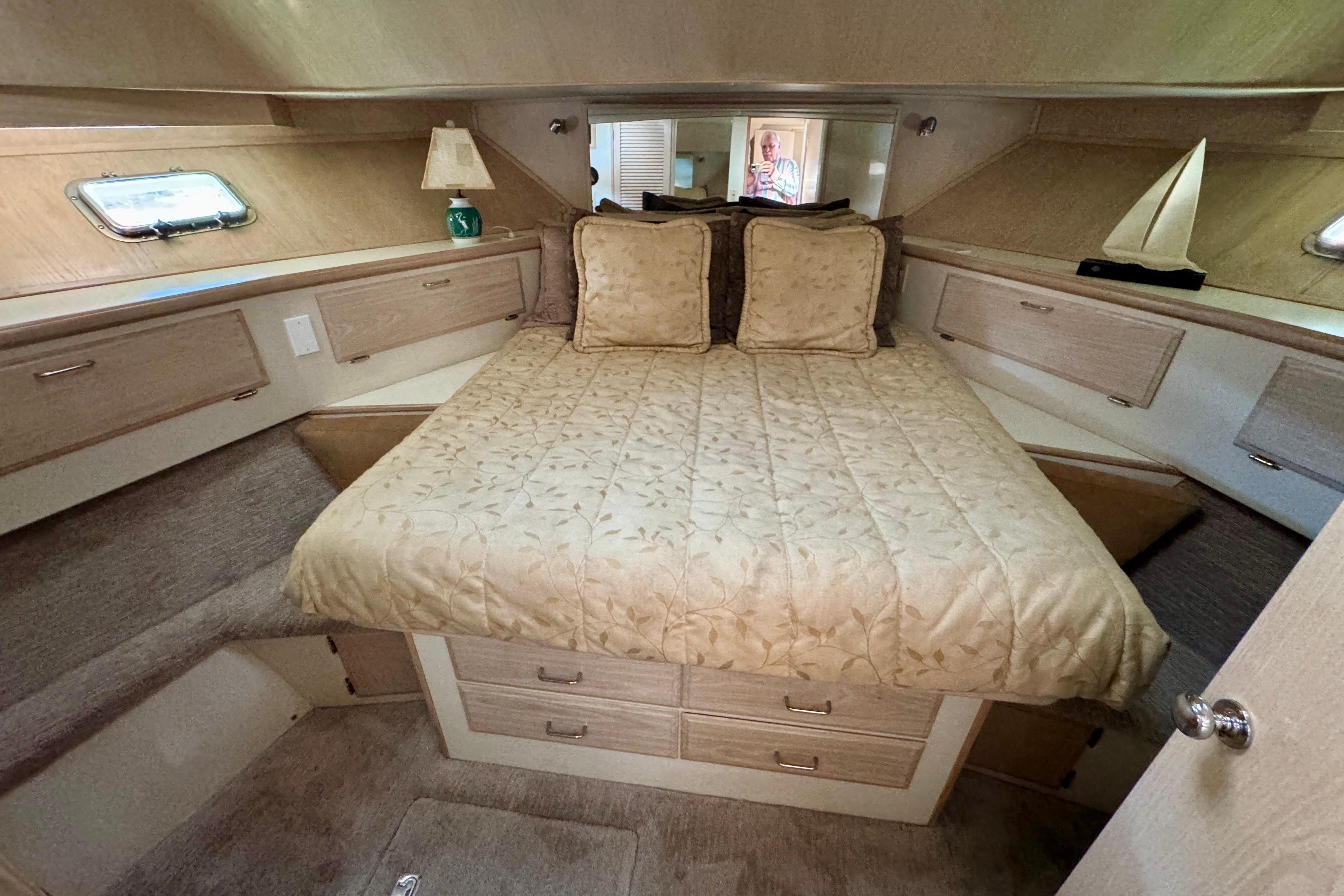 Luxurious bedroom in 1993 Tollycraft 57 Pilothouse Motor Yacht with elegant bedding and ample storage.