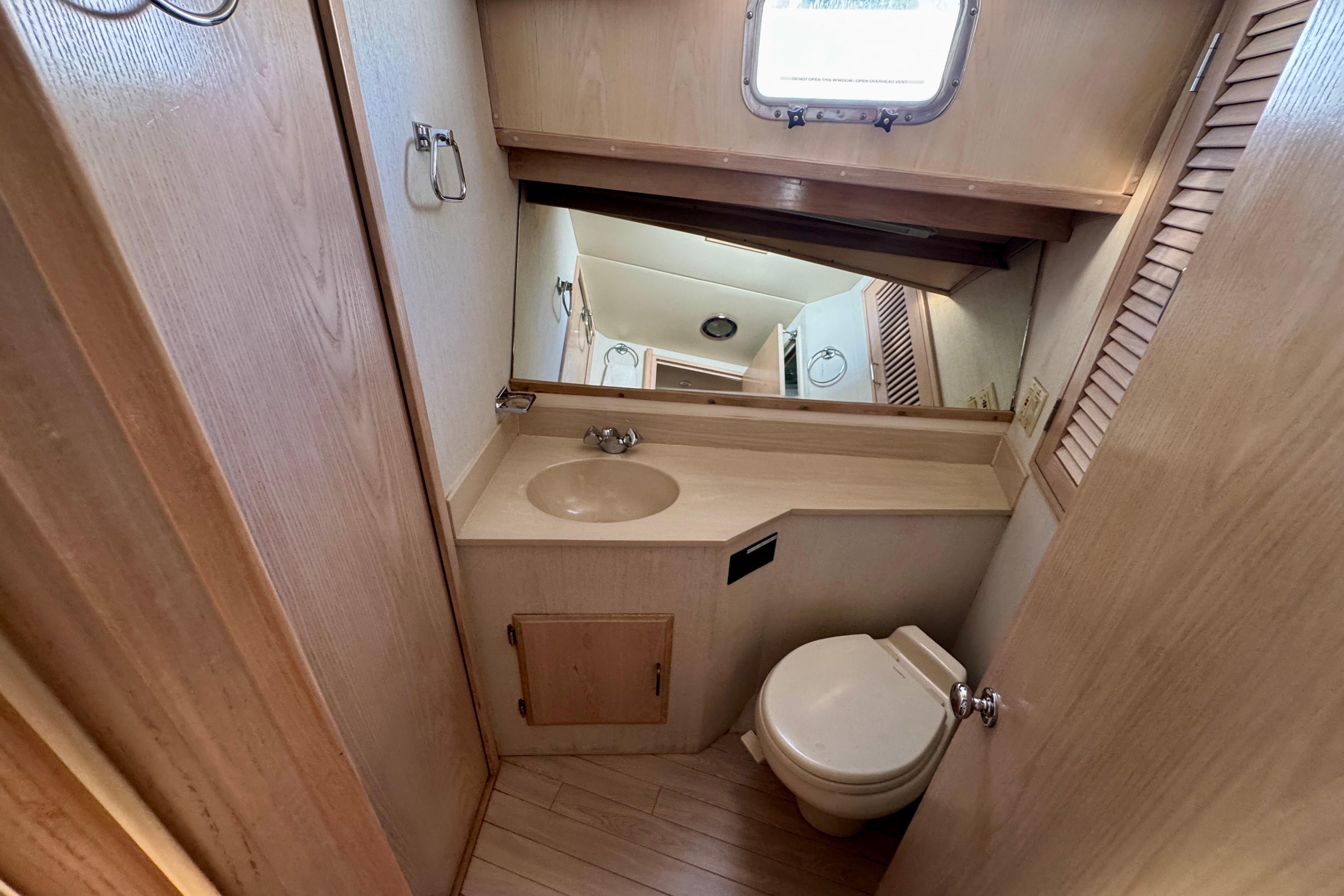 Bathroom interior of 1993 Tollycraft 57 Pilothouse Motor Yacht with sink and toilet.