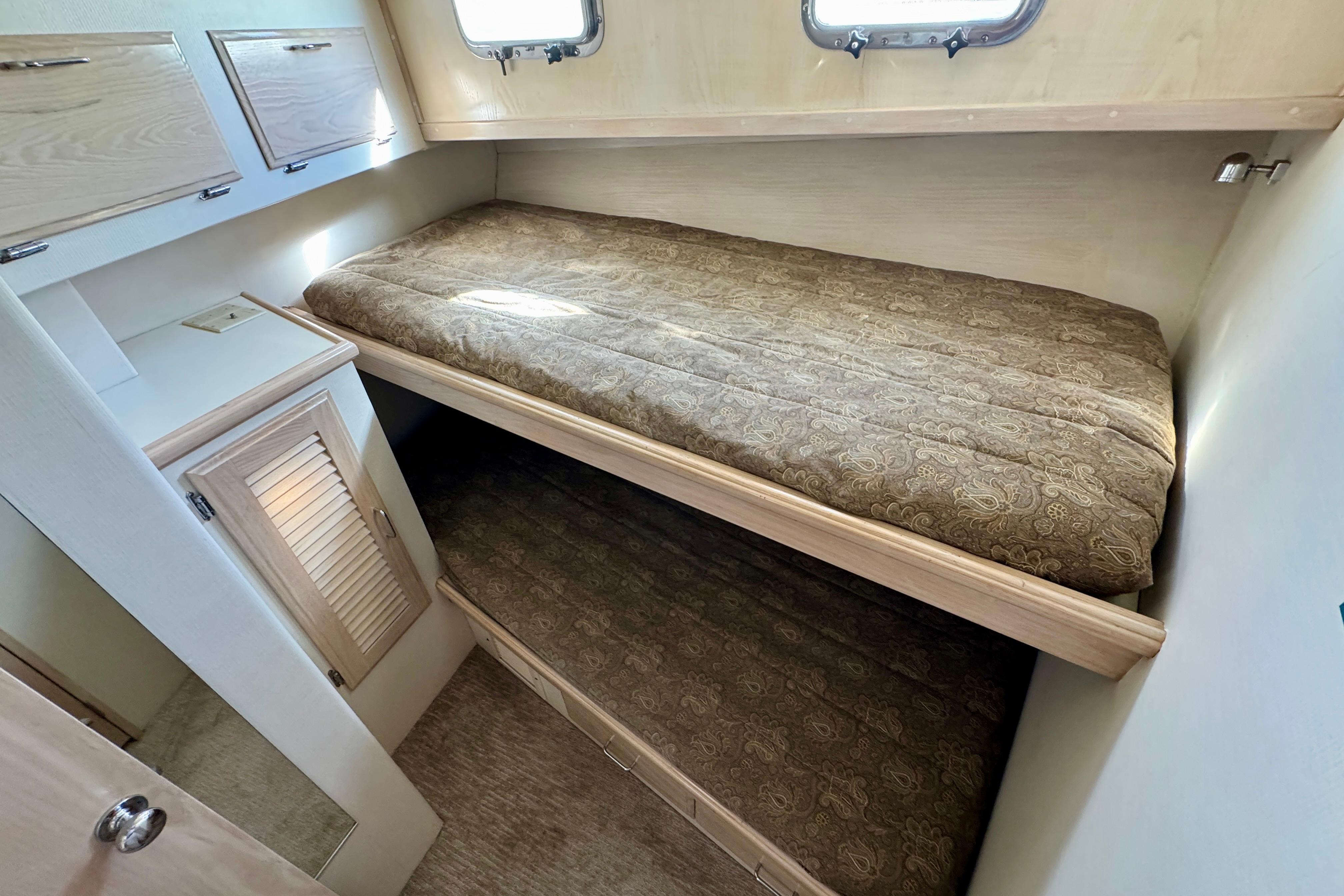 1993 Tollycraft 57 Pilothouse Motor Yacht cabin with bunk beds and storage cabinets.