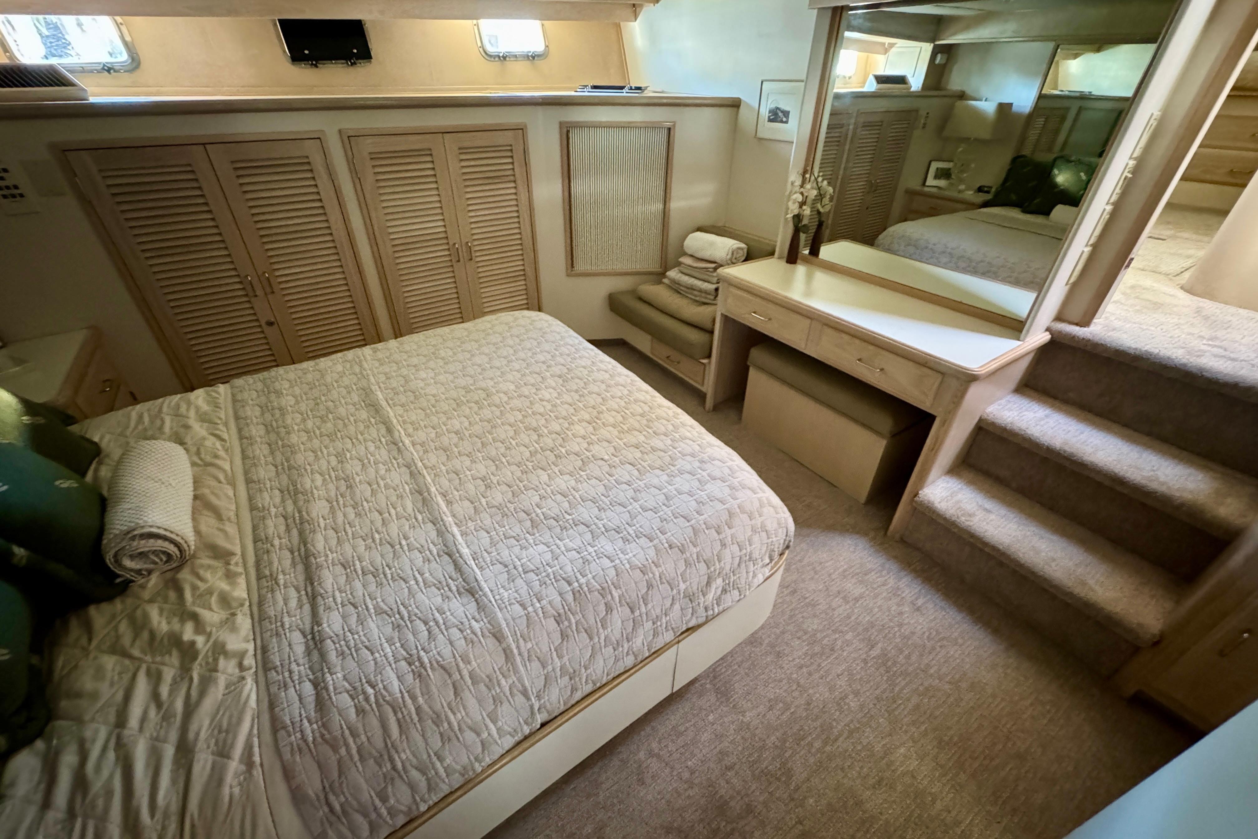 Luxurious bedroom in 1993 Tollycraft 57 Pilothouse Motor Yacht with cozy bedding and elegant decor.