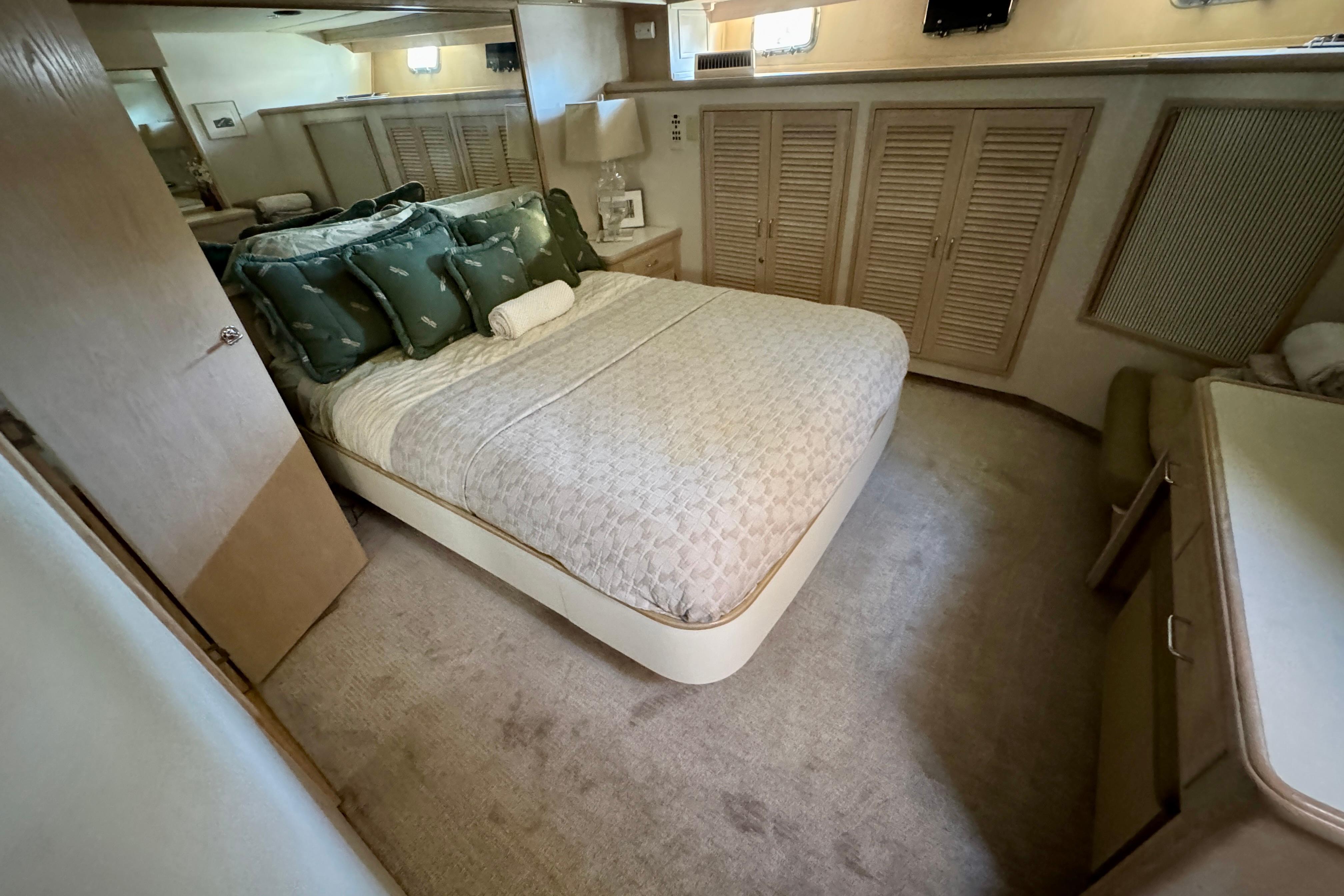 Luxurious bedroom interior of 1993 Tollycraft 57 Pilothouse Motor Yacht with elegant bedding.