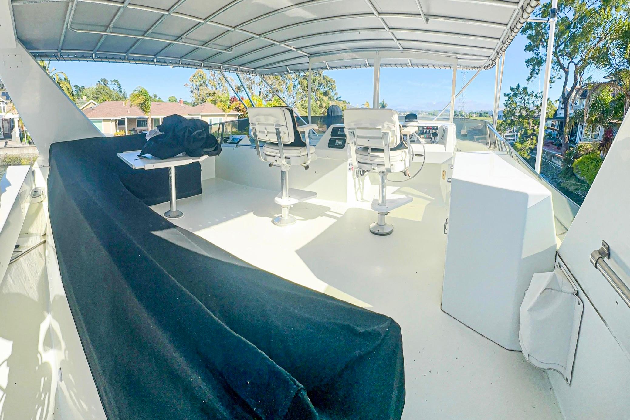 1993 Tollycraft 57 Pilothouse Motor Yacht upper deck with seating and controls.