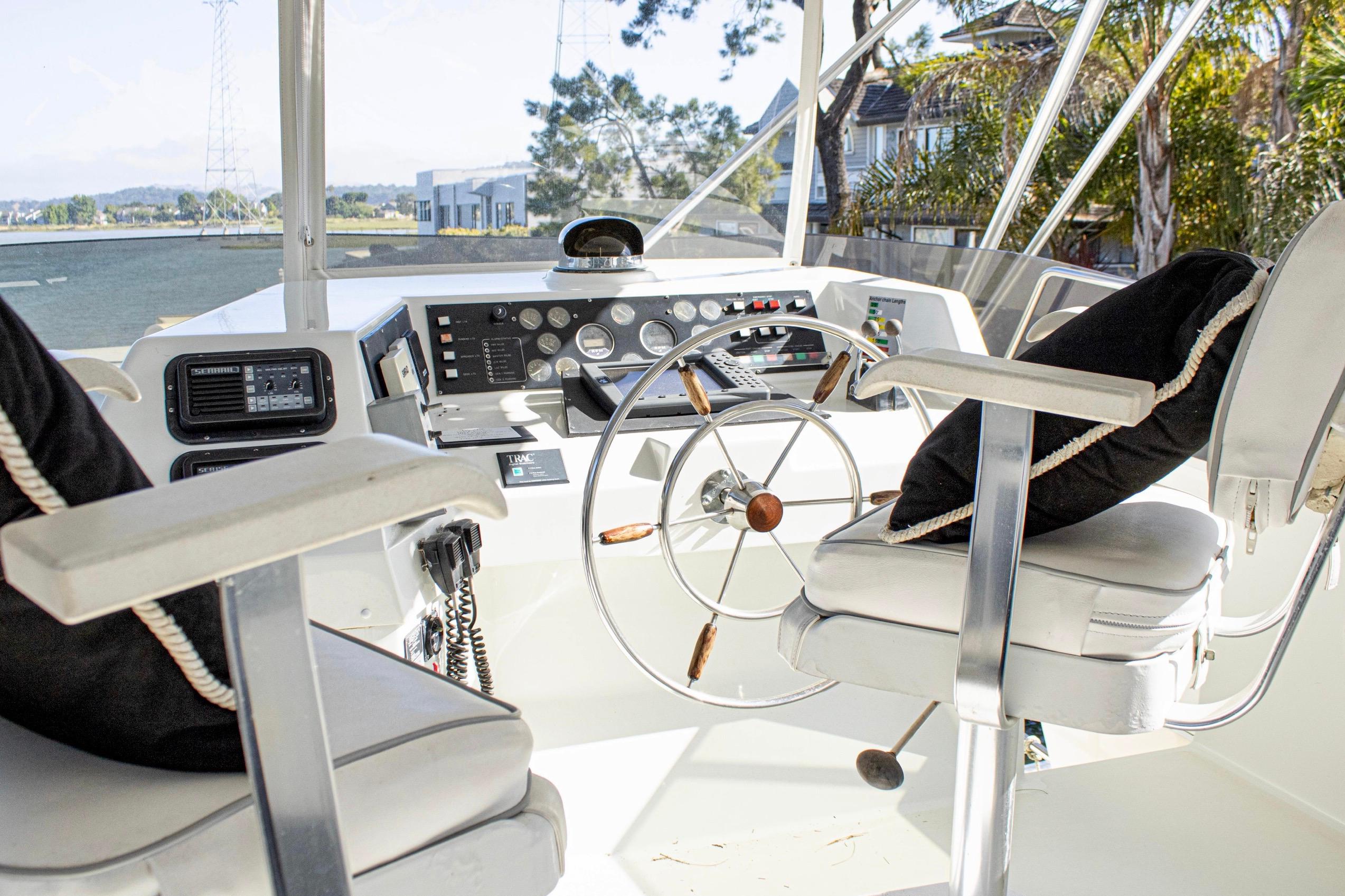 1993 Tollycraft 57 Pilothouse Motor Yacht helm with steering wheel and navigation controls.