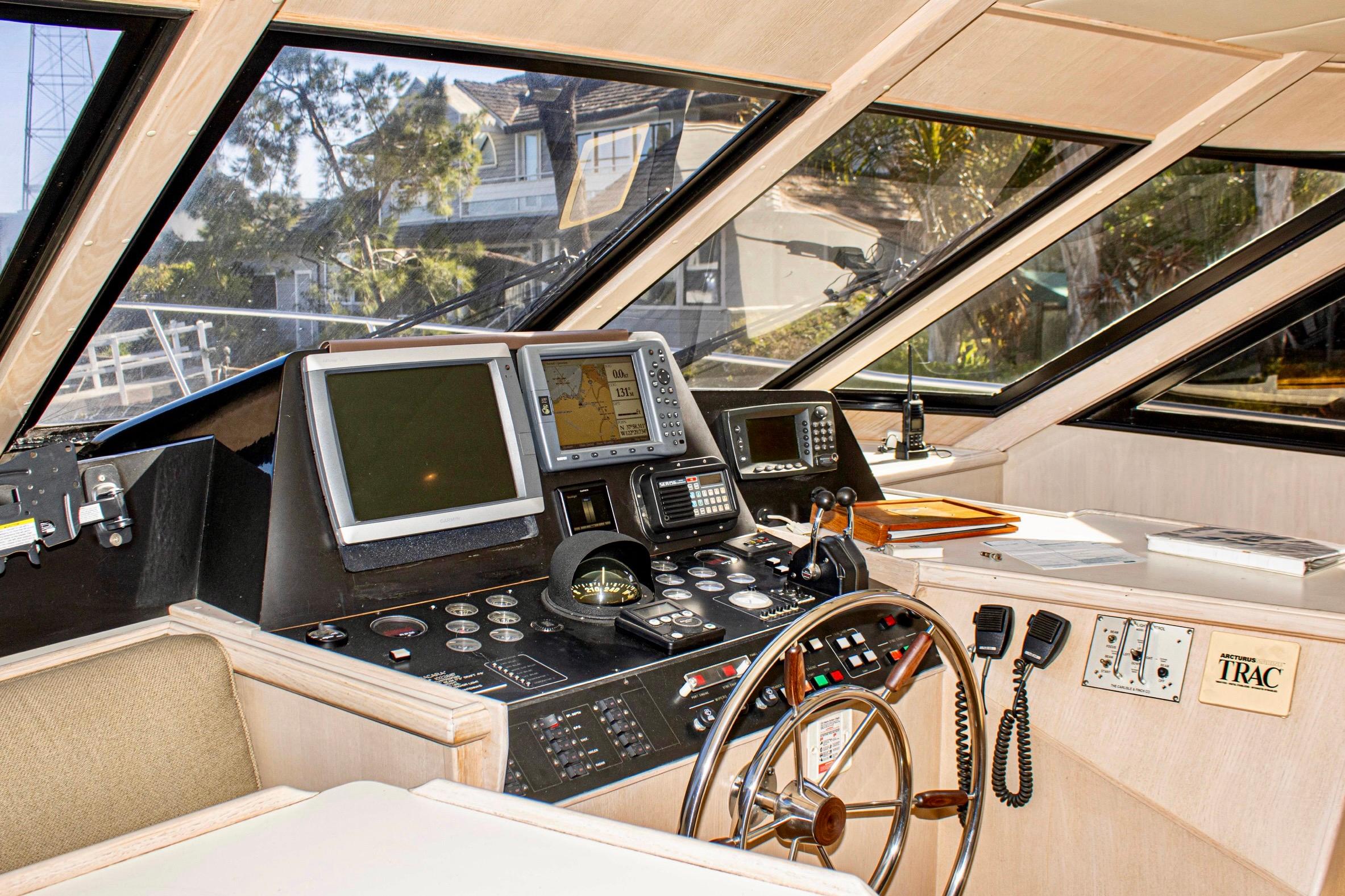Pilothouse interior of 1993 Tollycraft 57 Motor Yacht with navigation equipment and steering wheel.