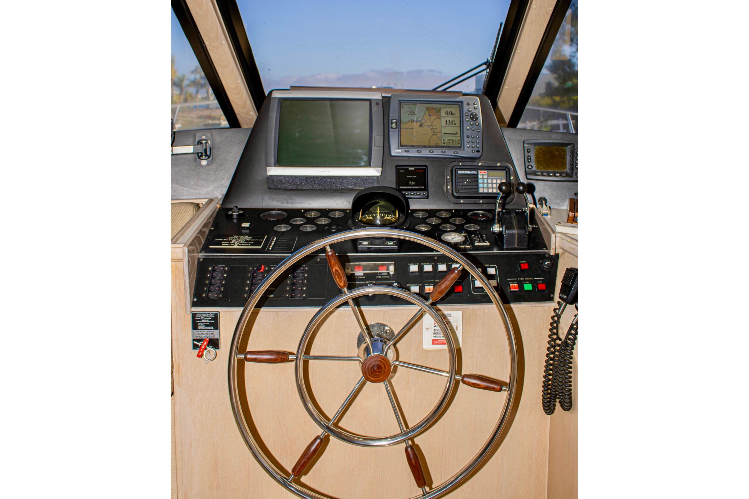 1993 Tollycraft 57 Pilothouse Motor Yacht helm with navigation instruments and steering wheel.