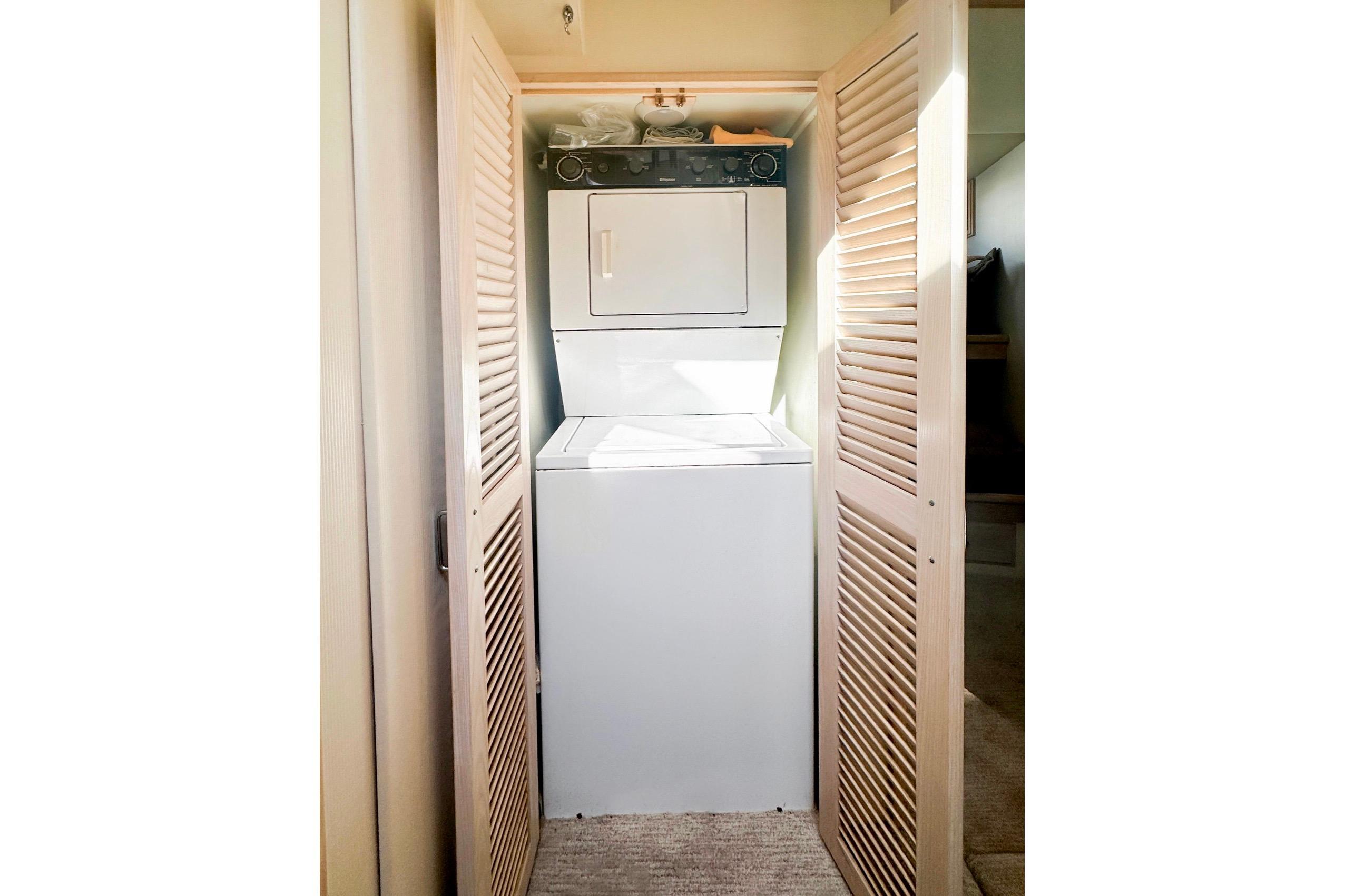 Laundry area with stacked washer and dryer in 1993 Tollycraft 57 Pilothouse Motor Yacht.