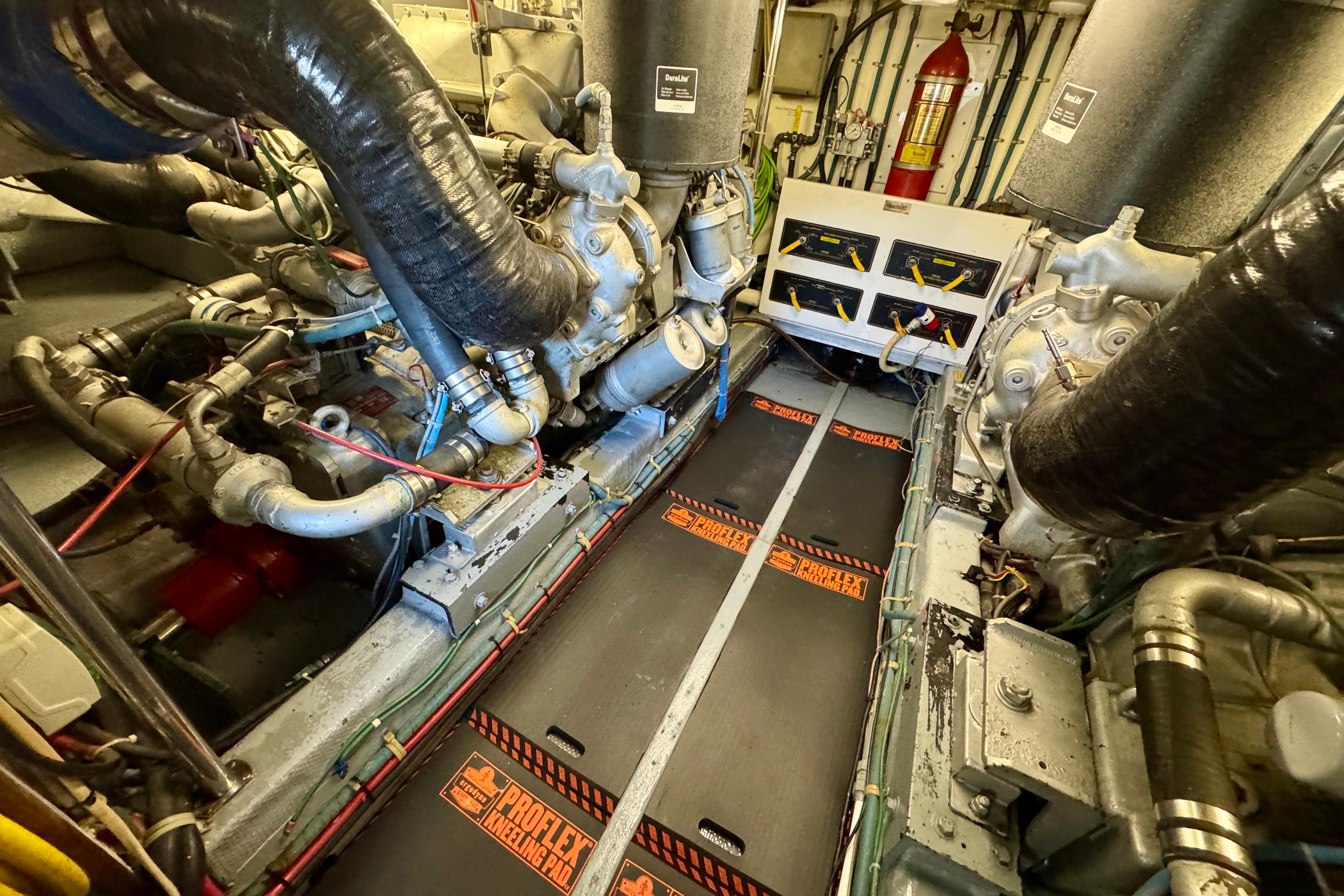 Engine room of 1993 Tollycraft 57 Pilothouse Motor Yacht, featuring complex machinery and control panels.