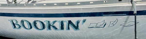 Camper & Nicholsons Nicholson 35 sailboat, 1984, named "Bookin'" with nautical graphics.