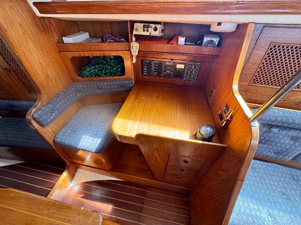 1984 Camper & Nicholsons Nicholson 35 yacht interior with wooden navigation station and seating.