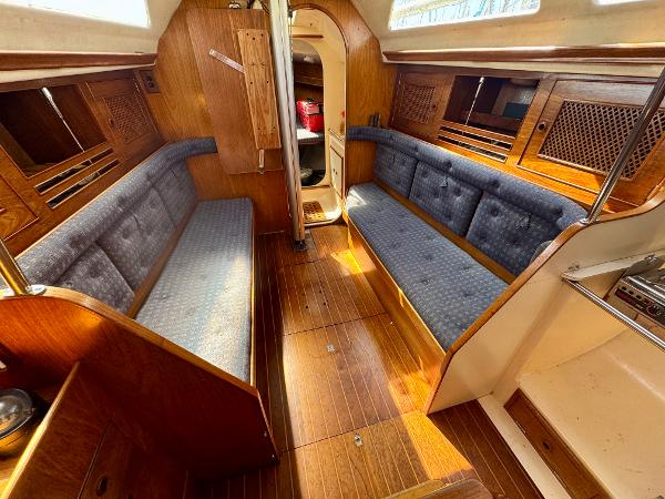 Interior of 1984 Camper & Nicholsons Nicholson 35 sailboat with wooden finish and blue seating.