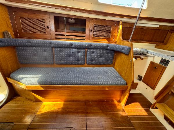 1984 Camper & Nicholsons Nicholson 35 yacht interior with wooden finish and blue cushioned seating.