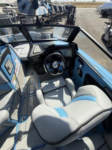 2025 Centurion Fe25 boat interior with blue and gray seating, modern dashboard, and steering wheel.