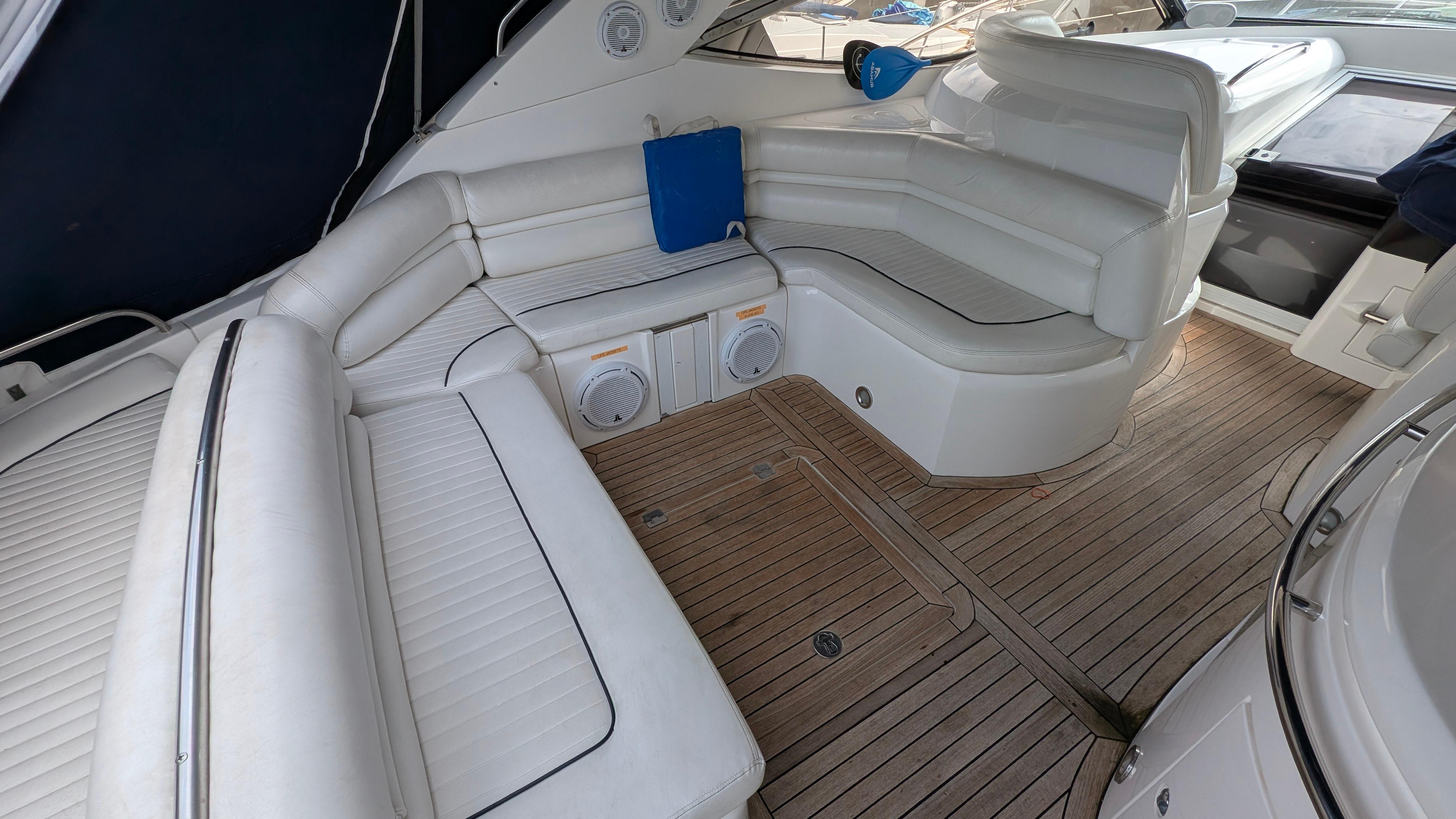 2004 Sunseeker Portofino yacht interior with white seating and wooden flooring.