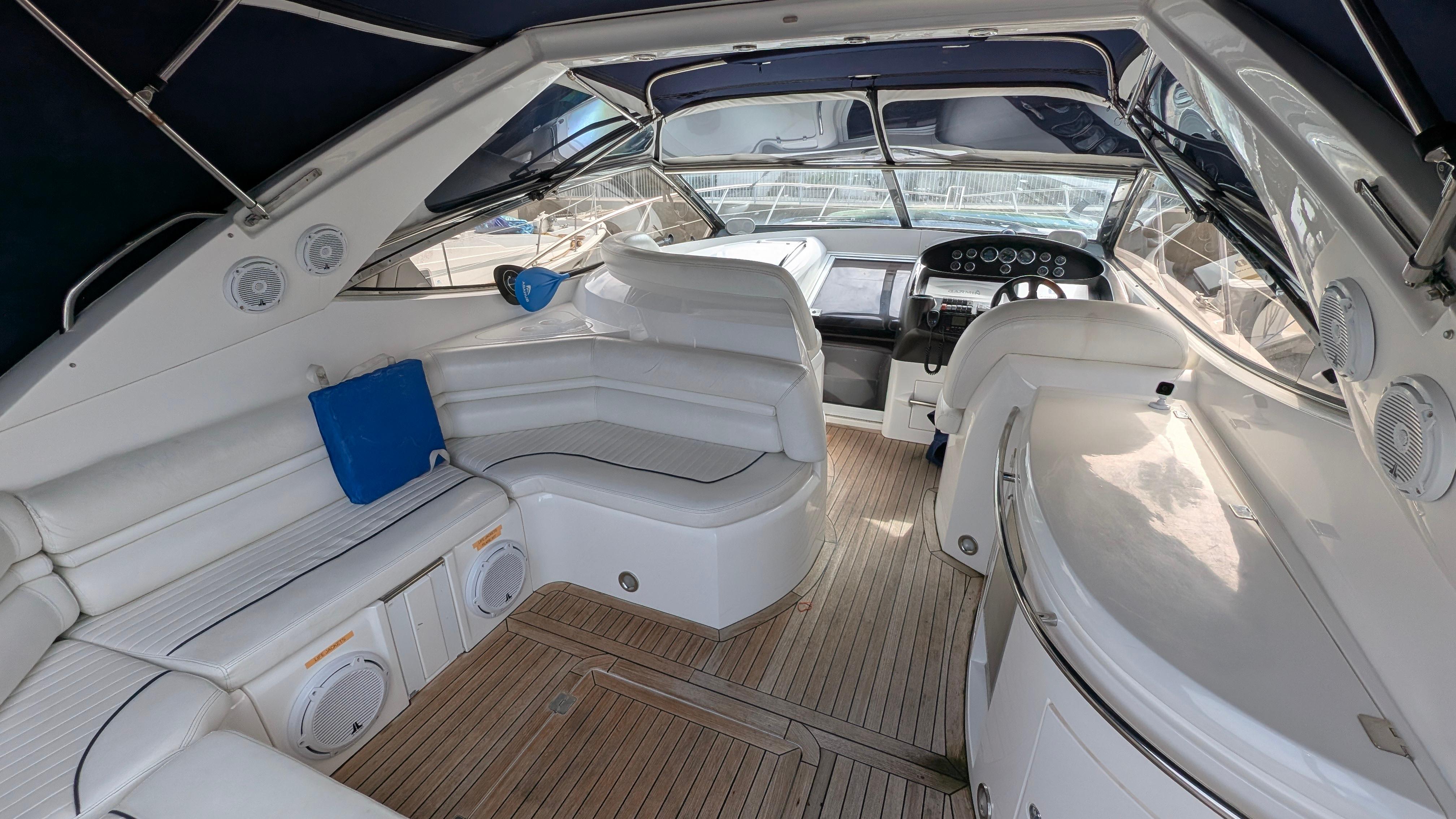 Luxurious 2004 Sunseeker Portofino yacht interior with white seating and wooden flooring.