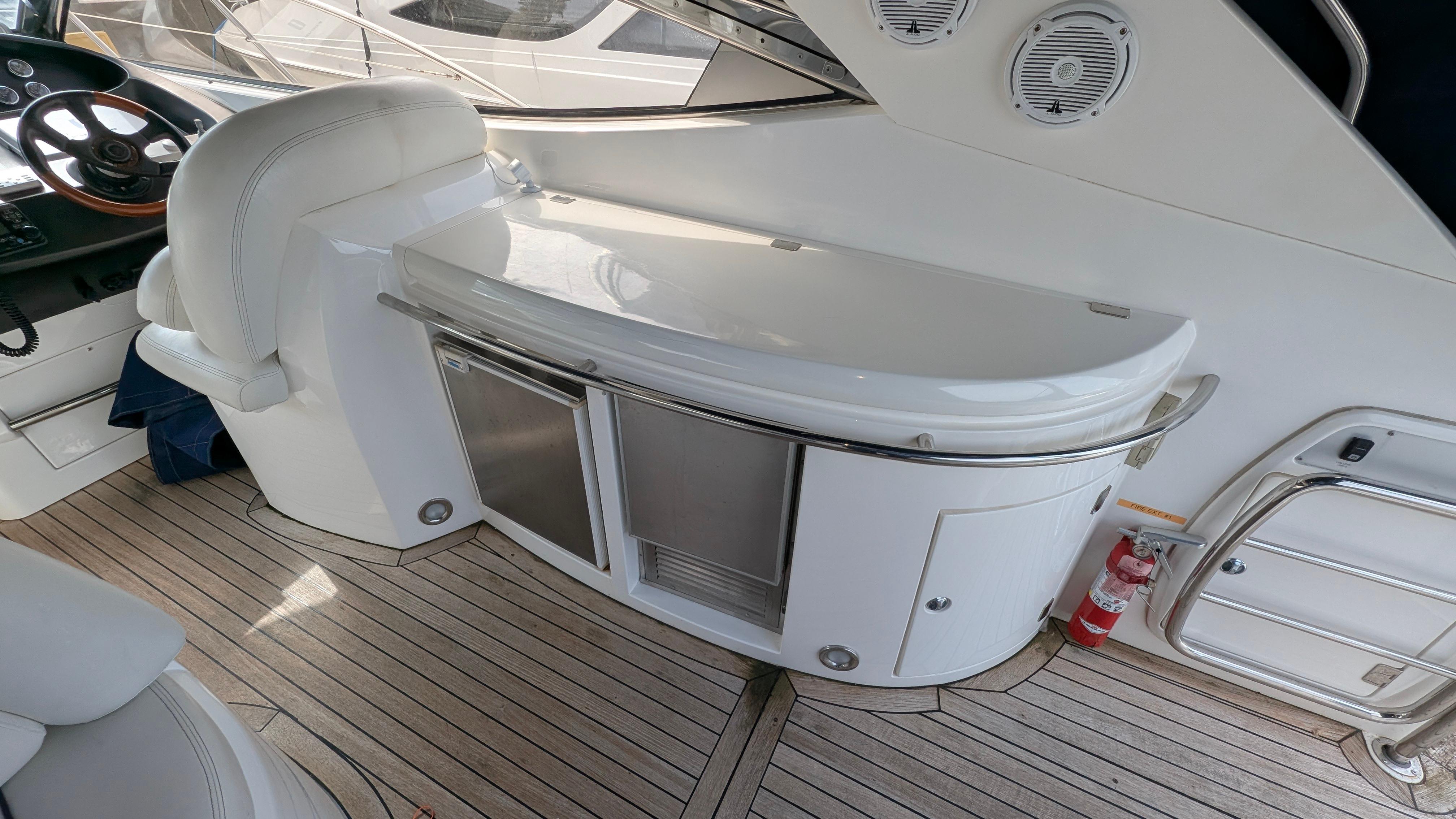 2004 Sunseeker Portofino yacht interior with sleek white seating and wooden flooring.