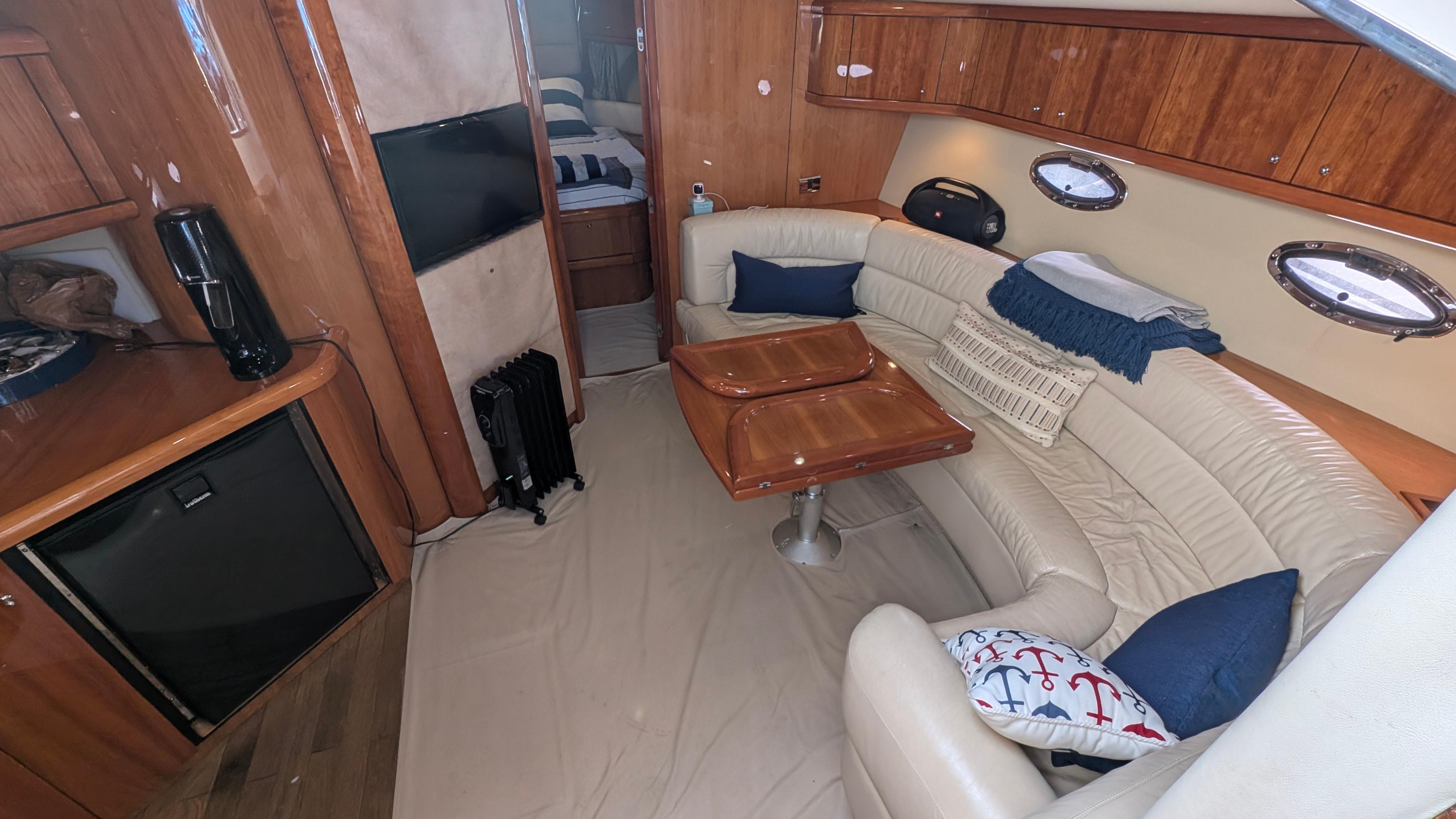 Luxurious 2004 Sunseeker Portofino yacht interior with plush seating and elegant wood finishes.