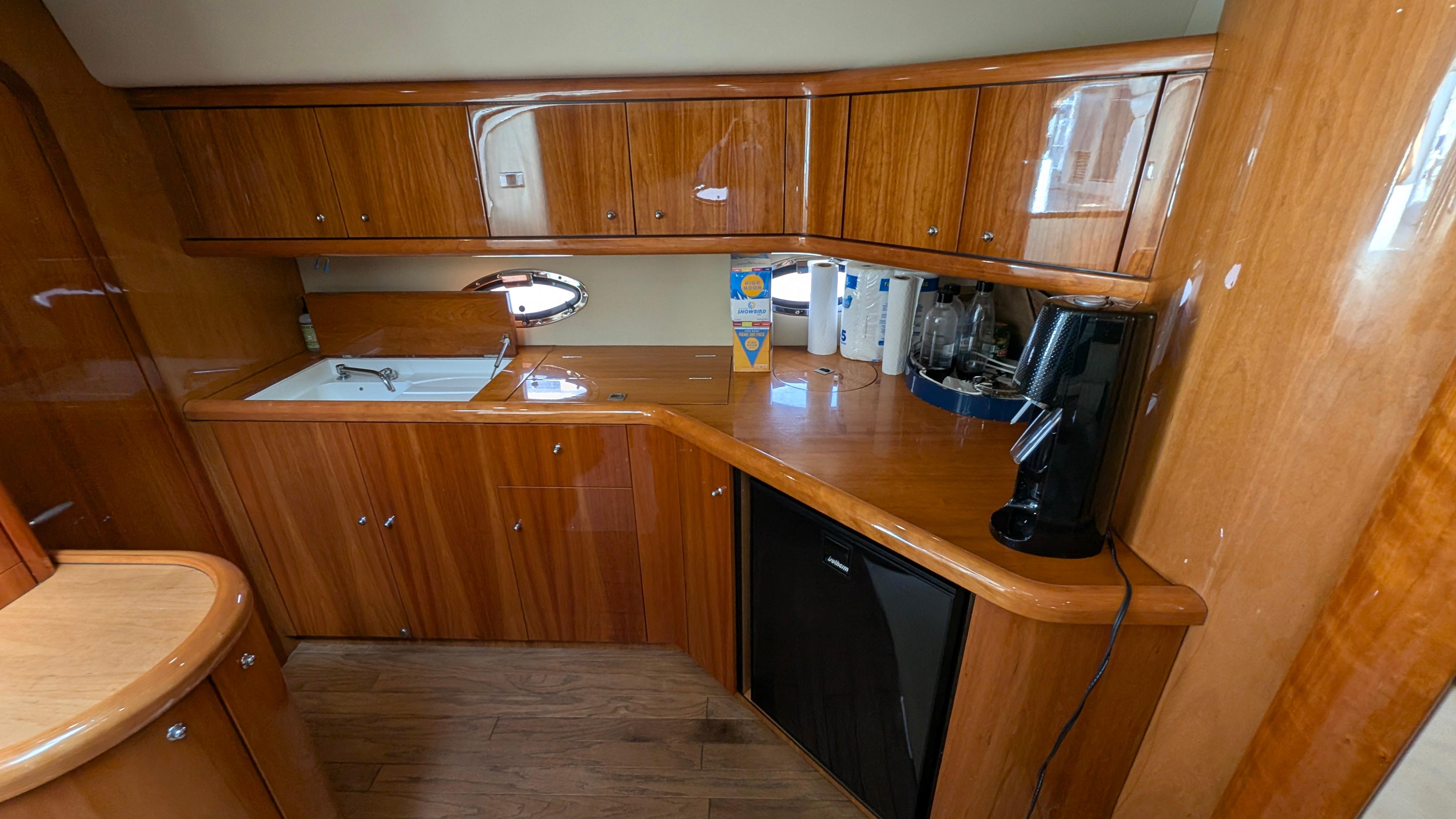 2004 Sunseeker Portofino yacht kitchen with wooden cabinets and modern appliances.