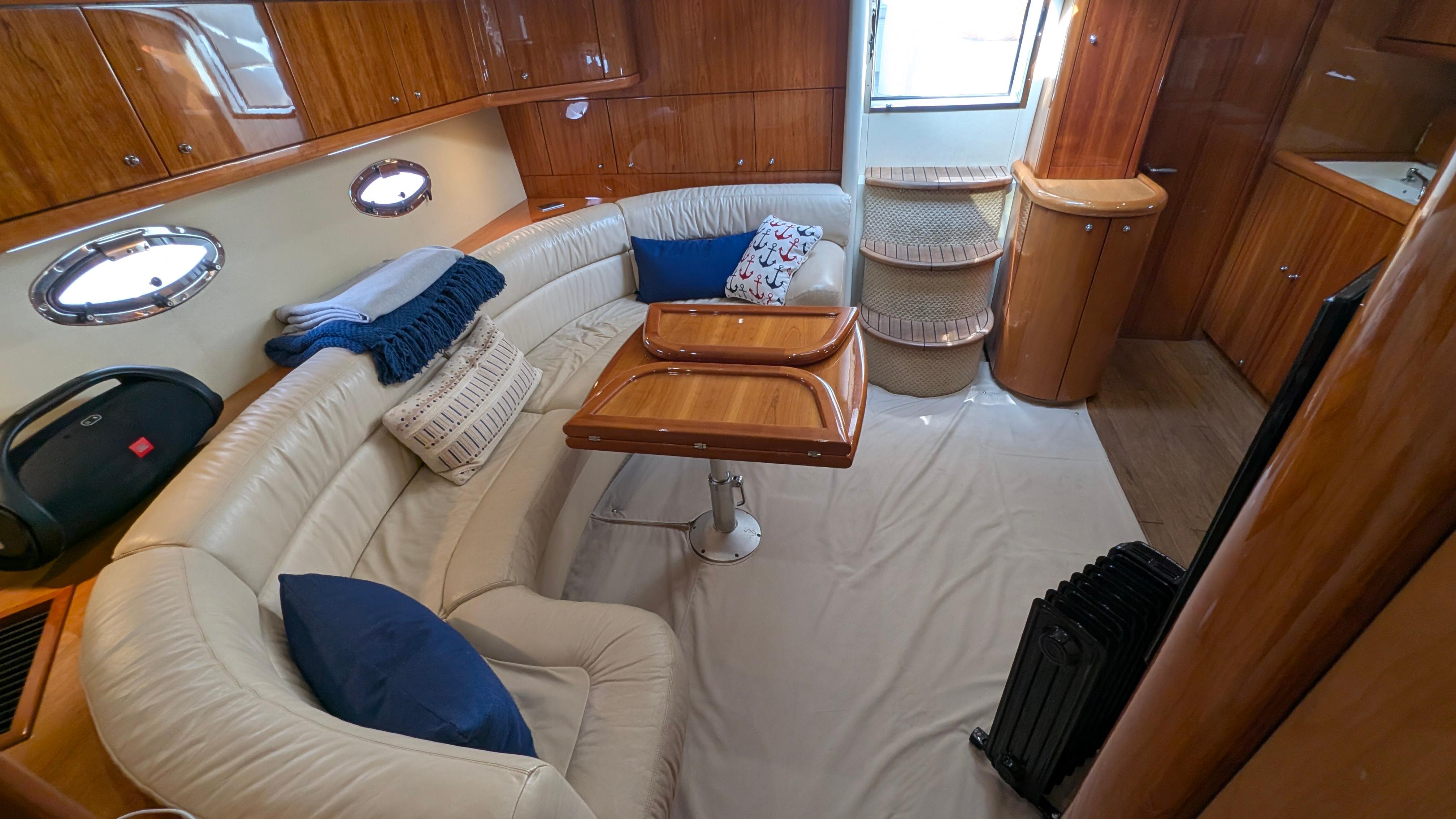 Luxurious 2004 Sunseeker Portofino yacht interior with elegant seating and wooden finishes.