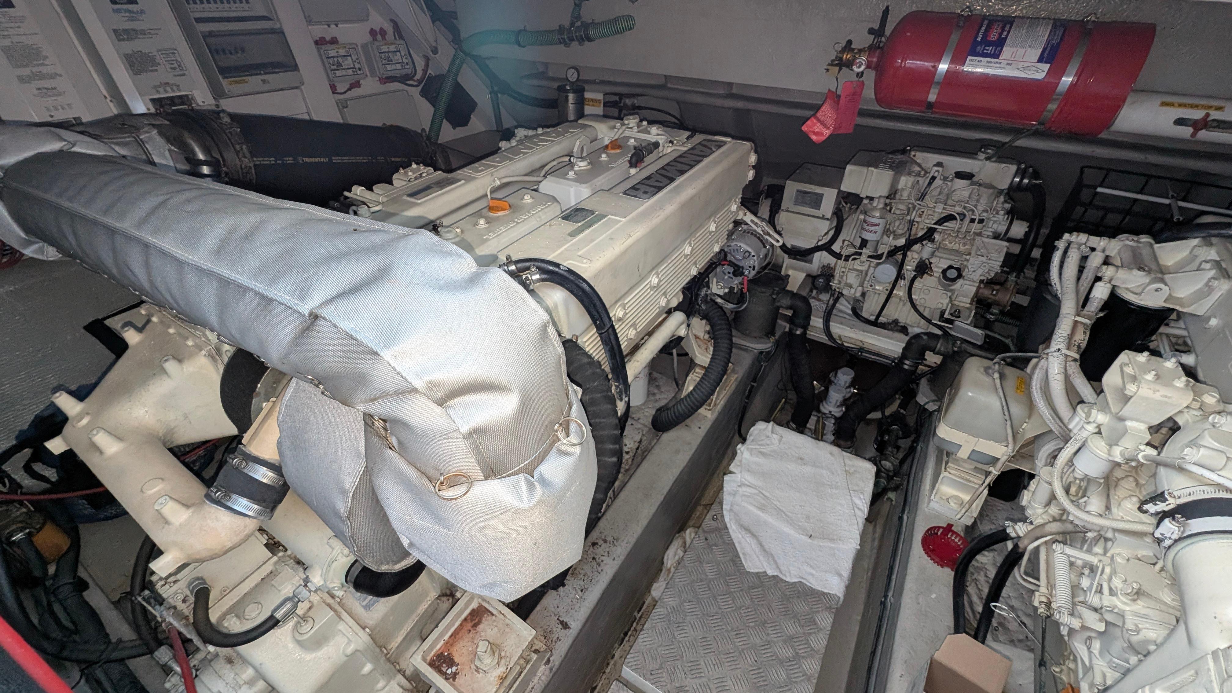 Engine room of a 2004 Sunseeker Portofino yacht, featuring mechanical components and fire extinguisher.