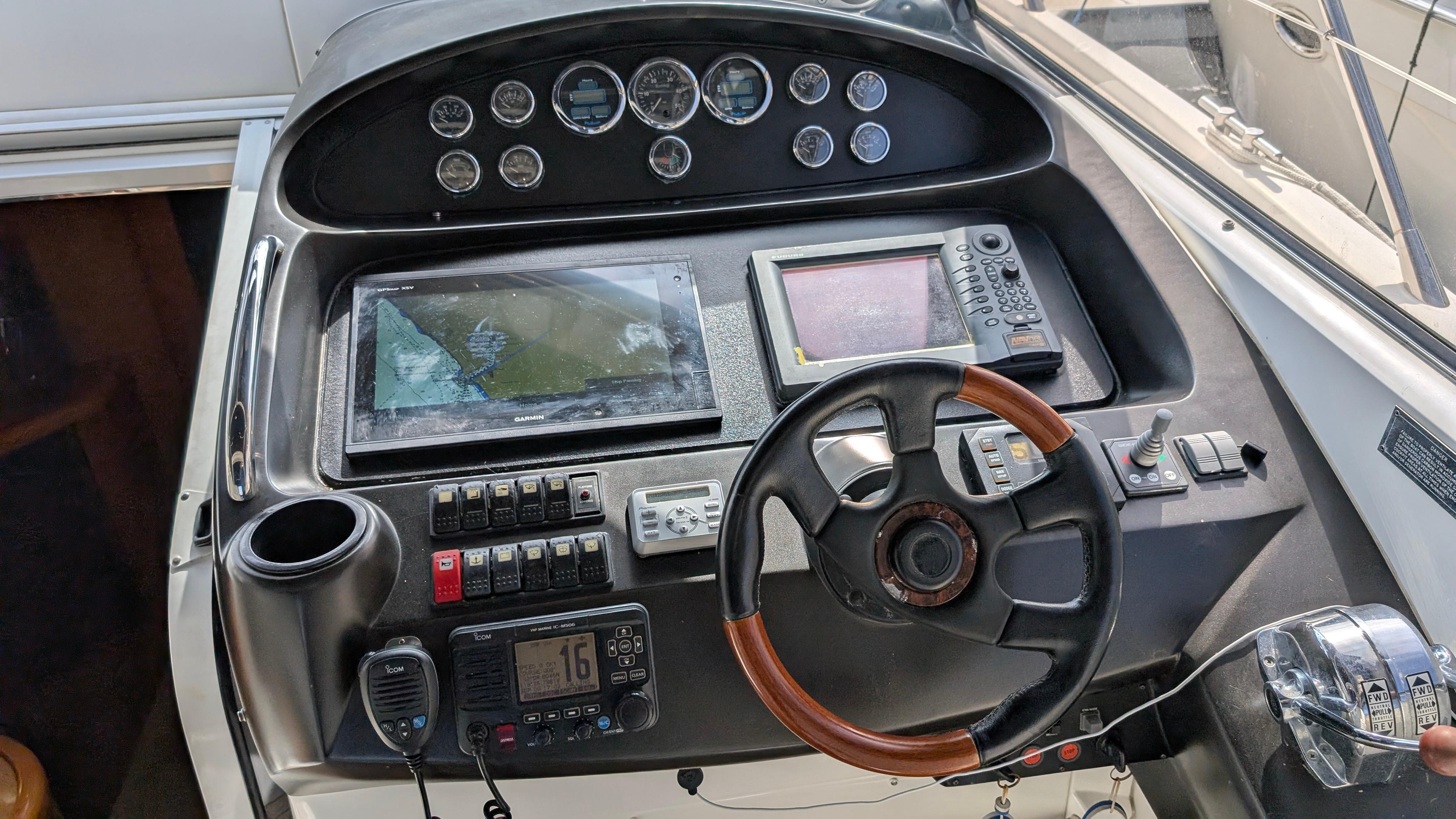 Control panel of a 2004 Sunseeker Portofino yacht with steering wheel and navigation instruments.