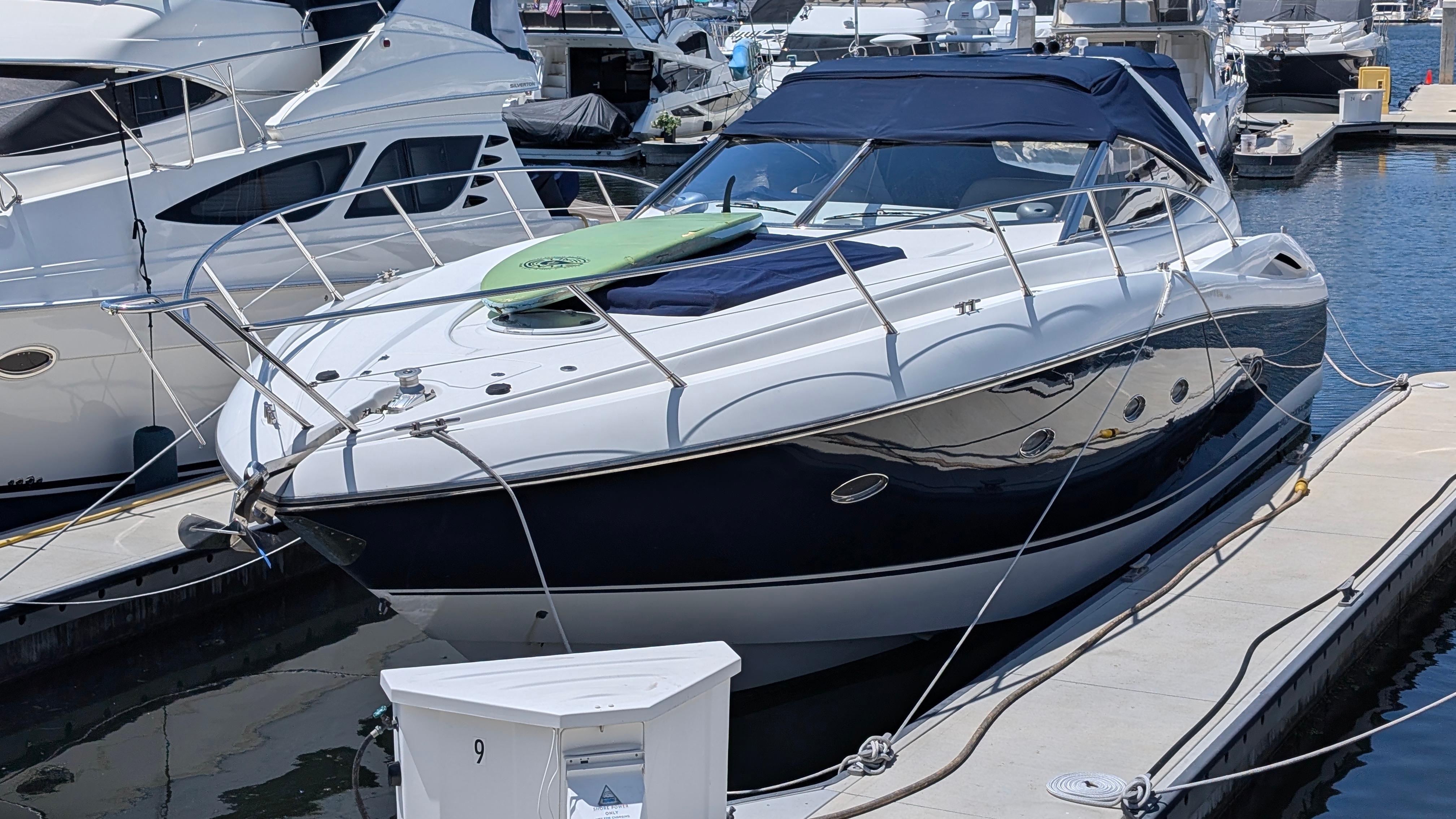 2004 Sunseeker Portofino yacht docked at marina, featuring sleek design and blue canopy.
