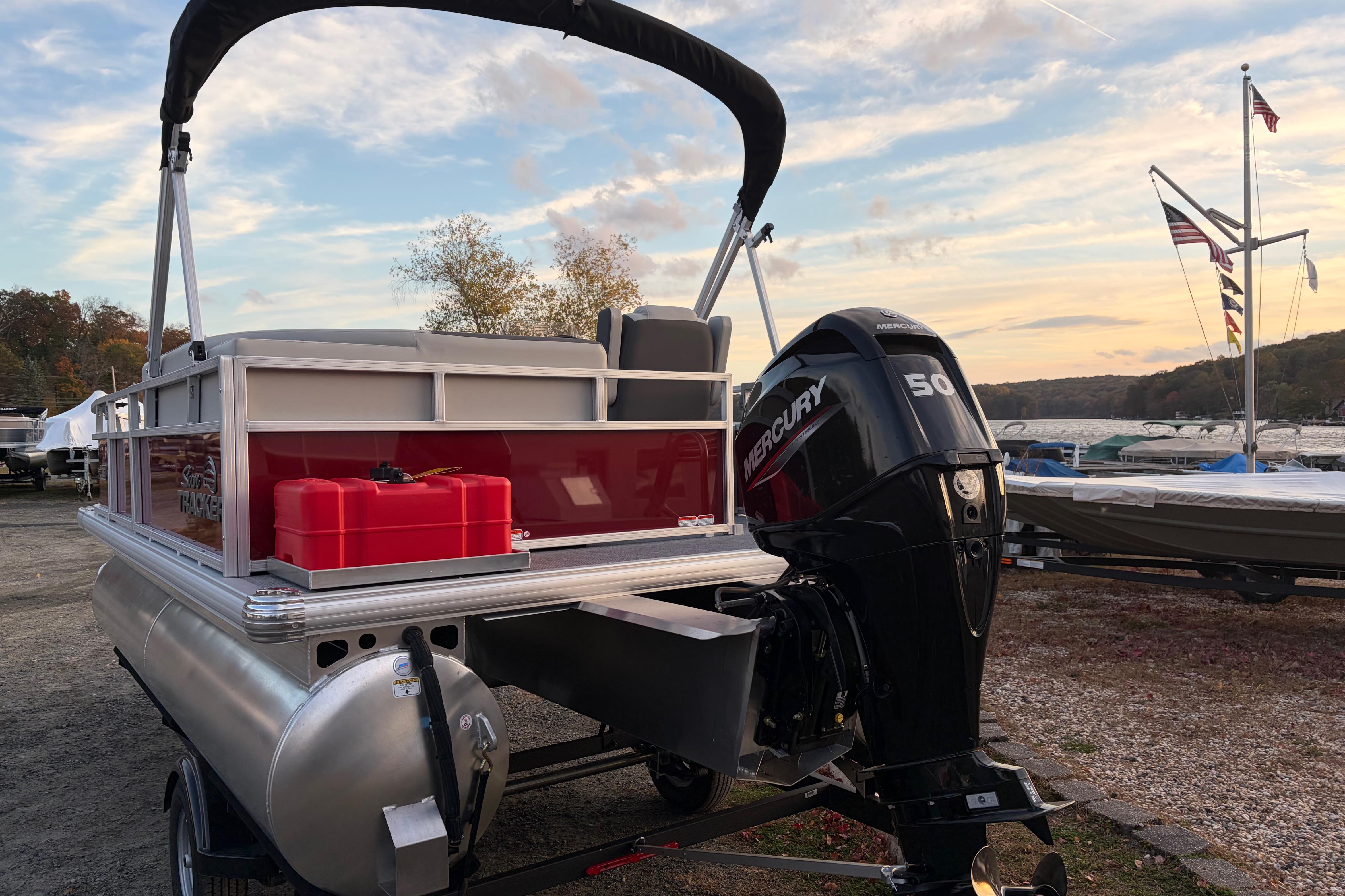 2026 Sun Tracker Bass Buggy 16 XL Select pontoon boat with Mercury 50 engine at sunset.