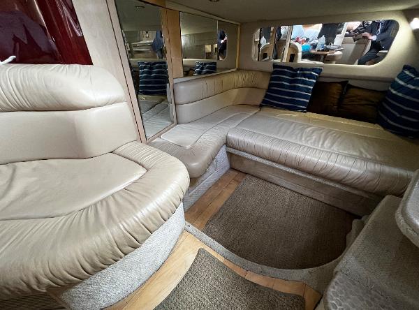 Luxurious interior of 2000 Sea Ray 380 Sundancer with beige leather seating and striped pillows.