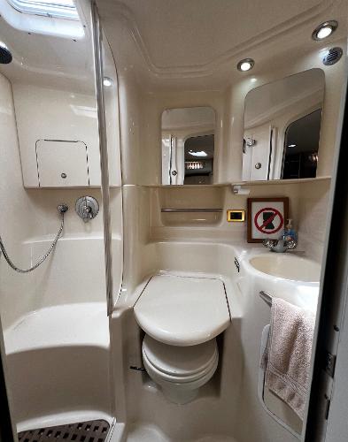 Compact bathroom in 2000 Sea Ray 380 Sundancer yacht, featuring toilet, shower, and storage.