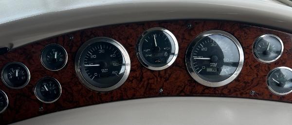 Dashboard of a 2000 Sea Ray 380 Sundancer with multiple gauges and wood paneling.