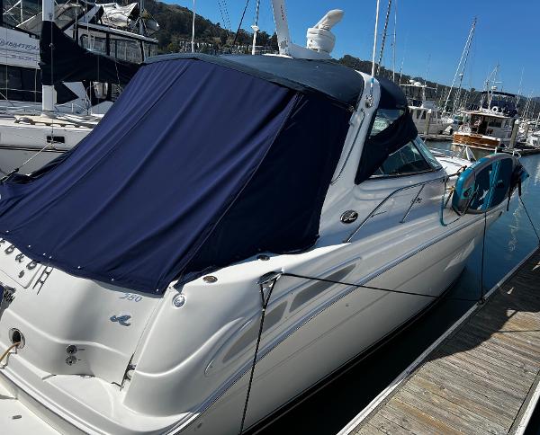 2000 Sea Ray 380 Sundancer docked at marina with blue cover.