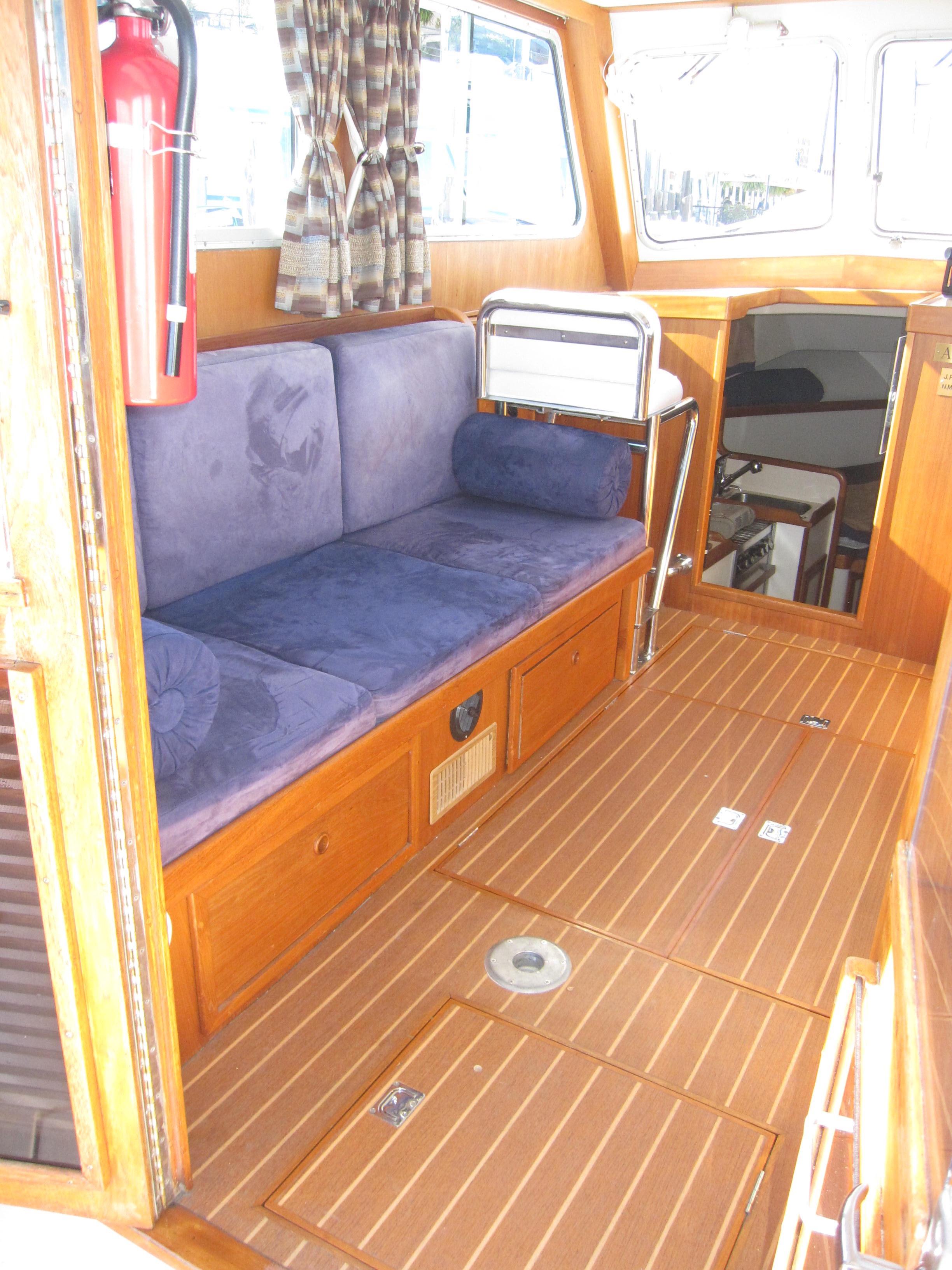 1990 Blue Seas 31 Hardtop Cruiser interior with wooden flooring and blue seating.