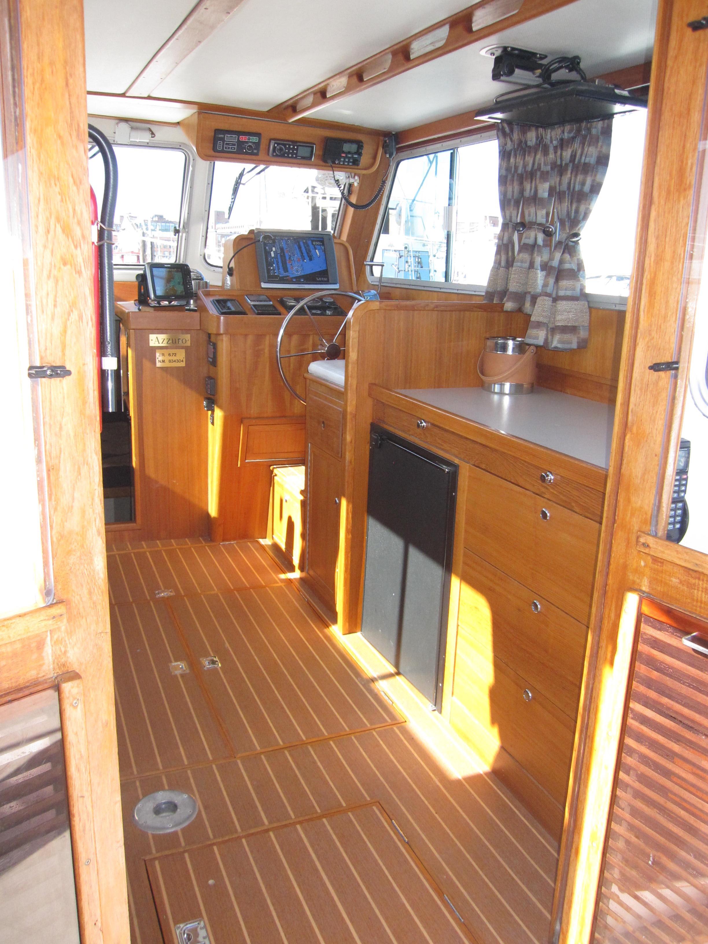 Interior of 1990 Blue Seas 31 Hardtop Cruiser with wooden cabinetry and modern navigation equipment.